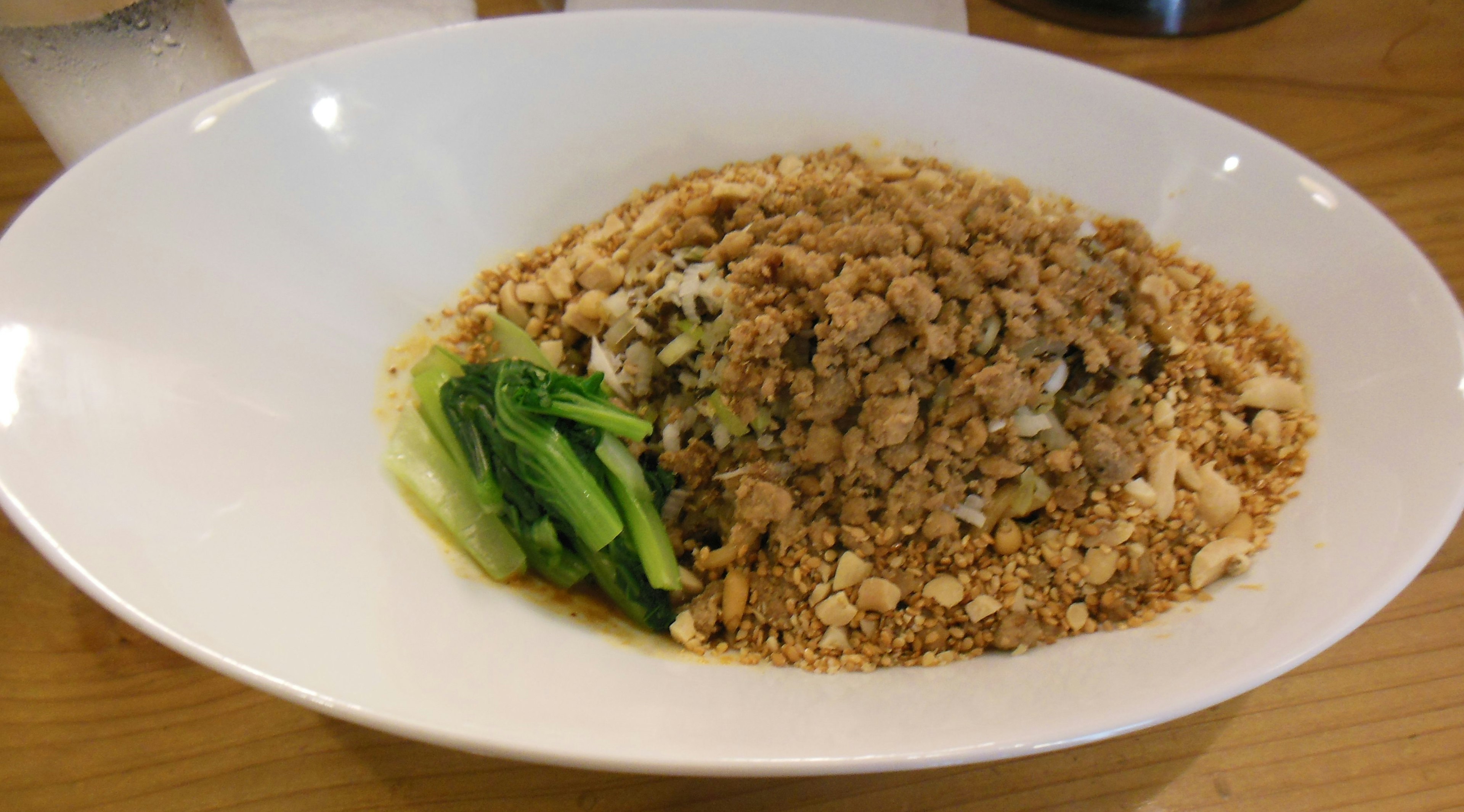 Dish of fragrant rice topped with crushed peanuts and served with green vegetables