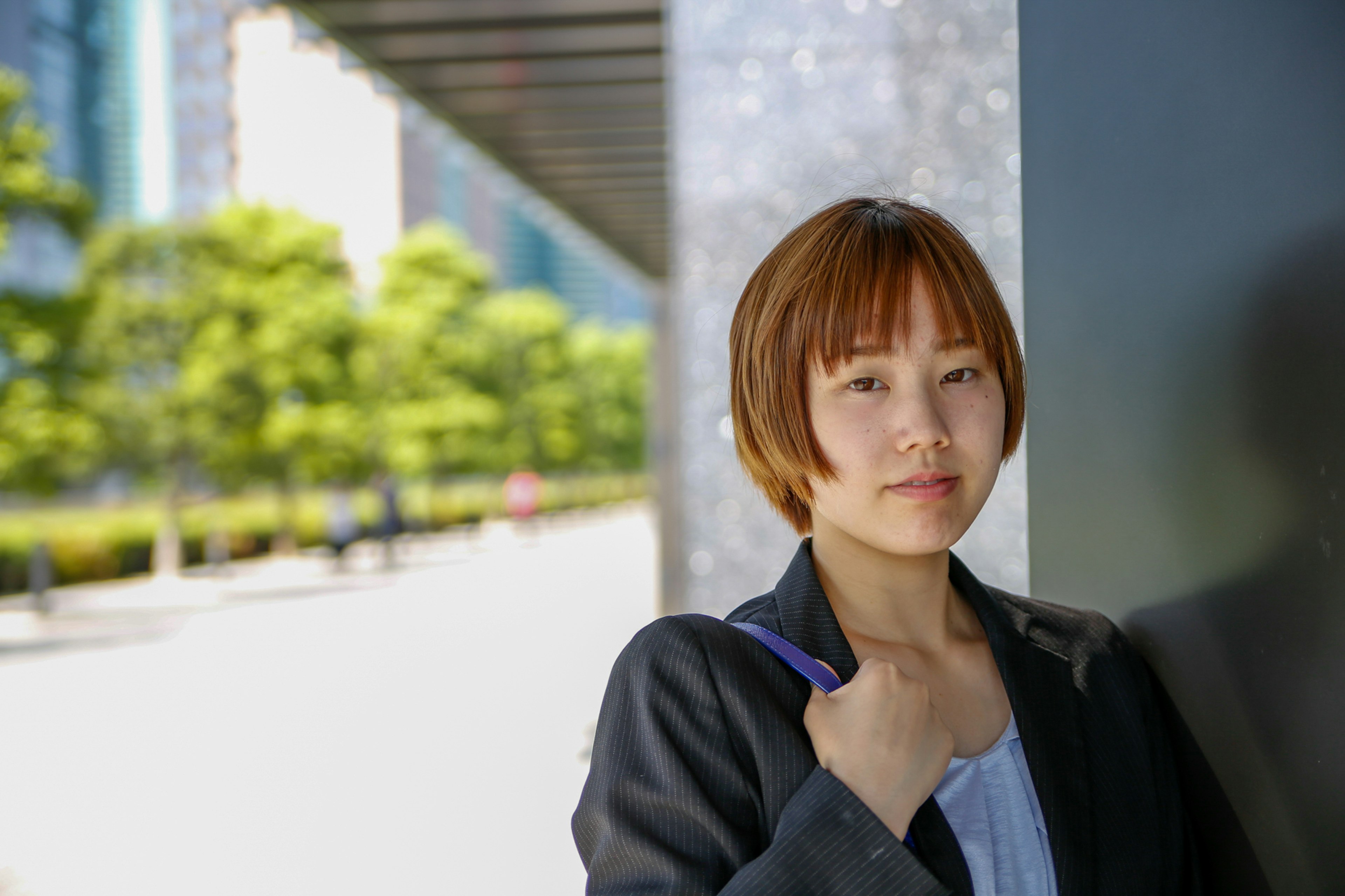 Young woman in business attire standing in an urban setting