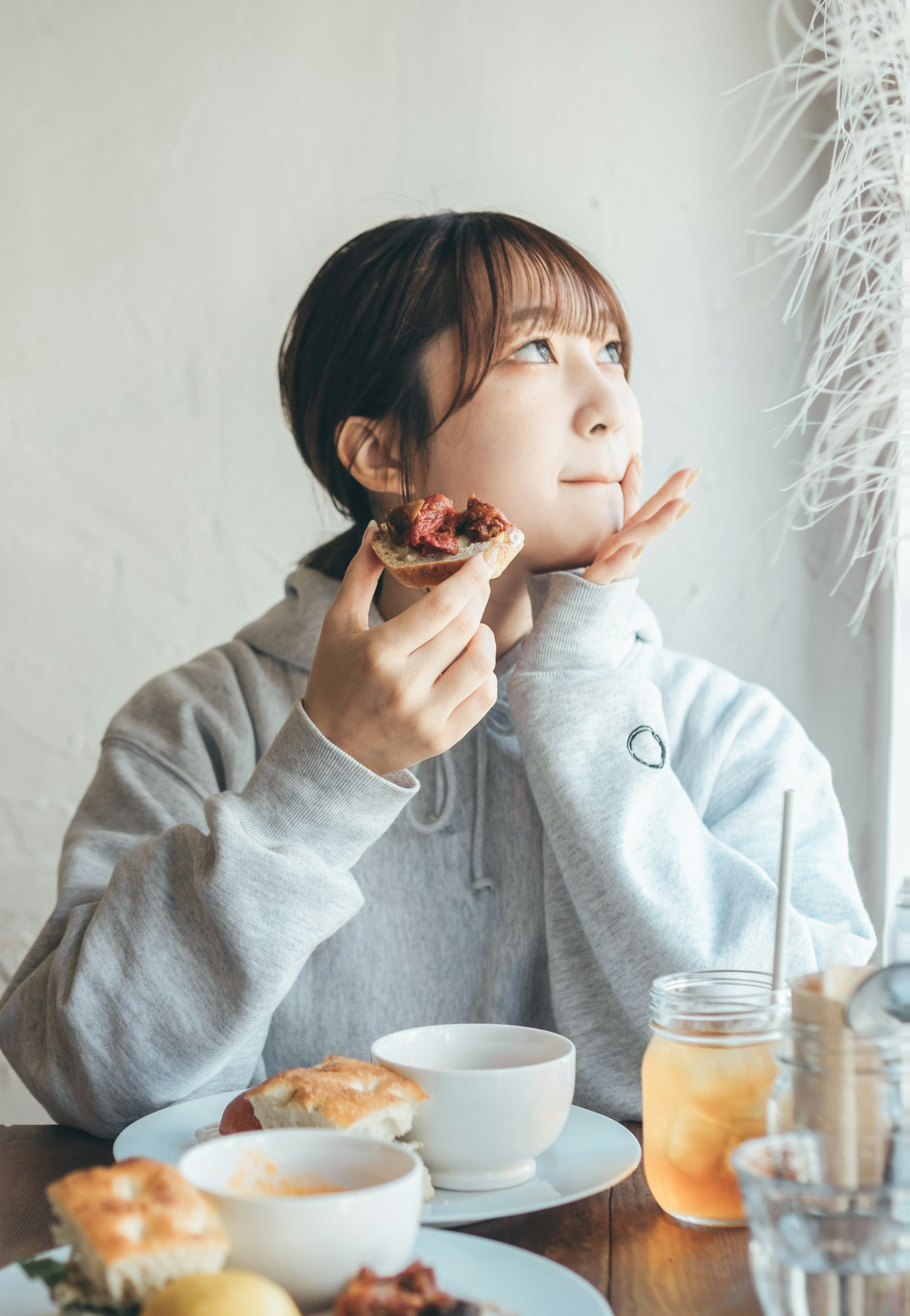 A woman enjoying a meal while deep in thought