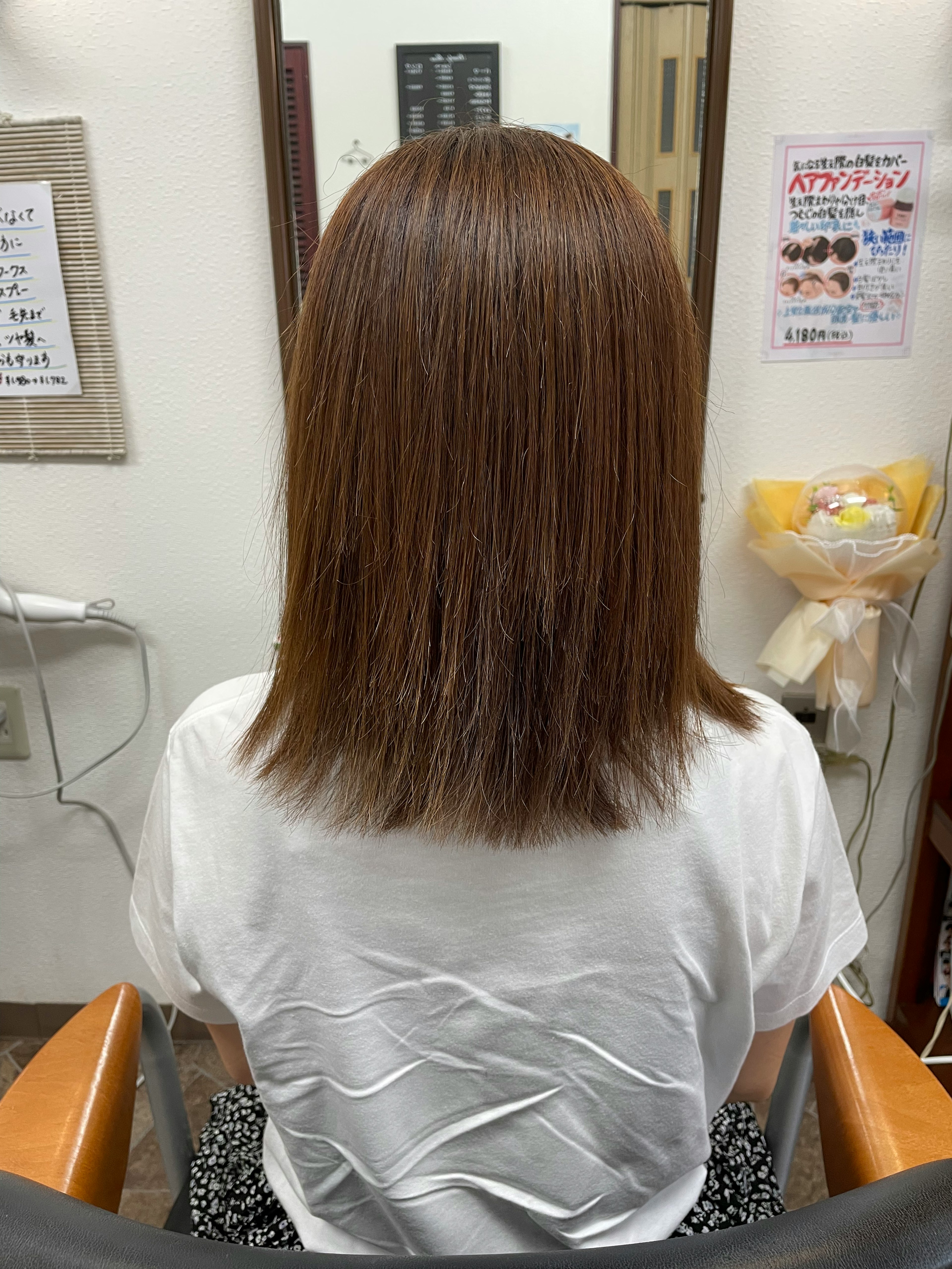 Back view of a woman with styled hair in a salon mirror reflection