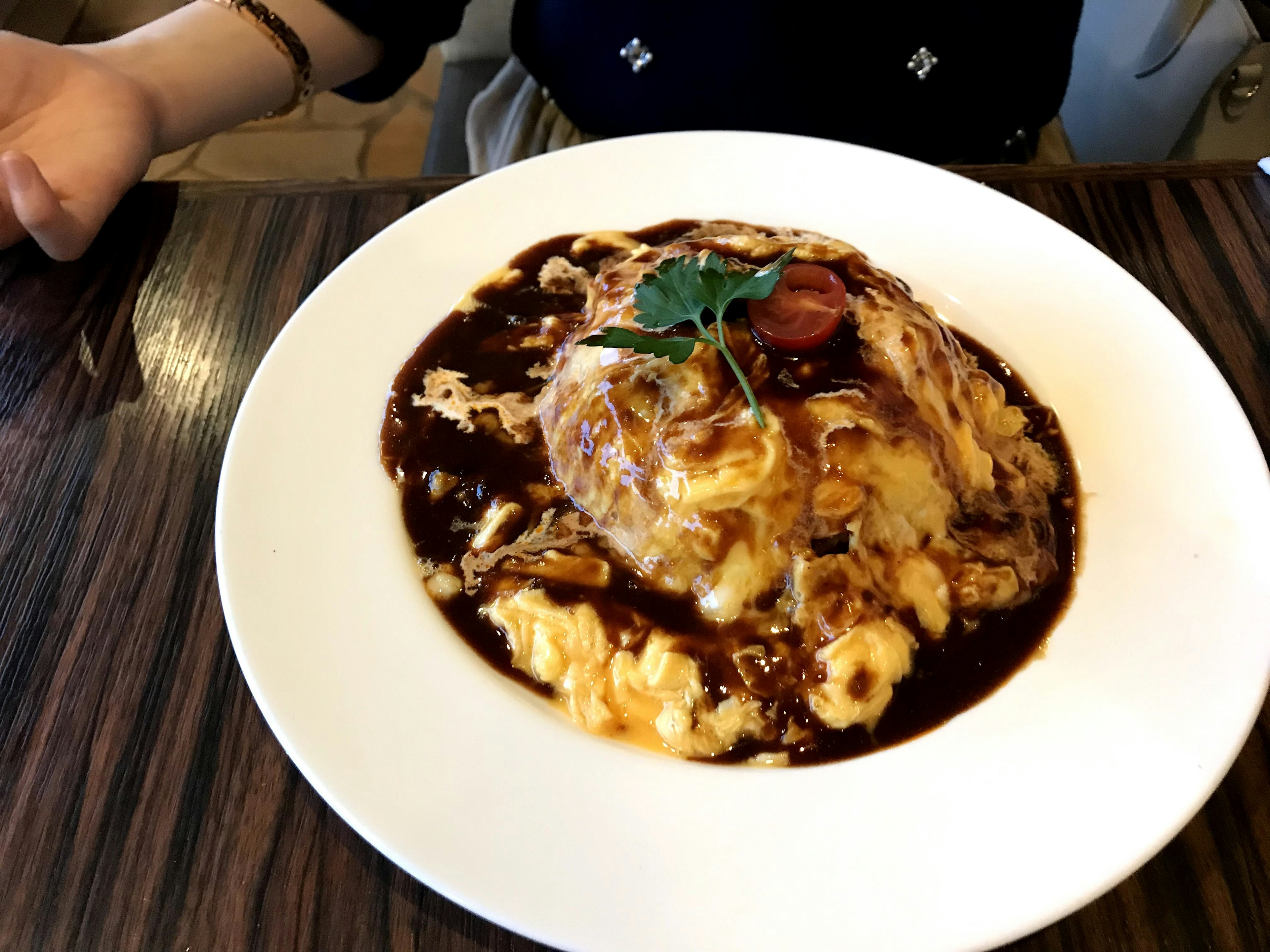 Omelette de riz garnie de sauce crémeuse et d'une tomate cerise