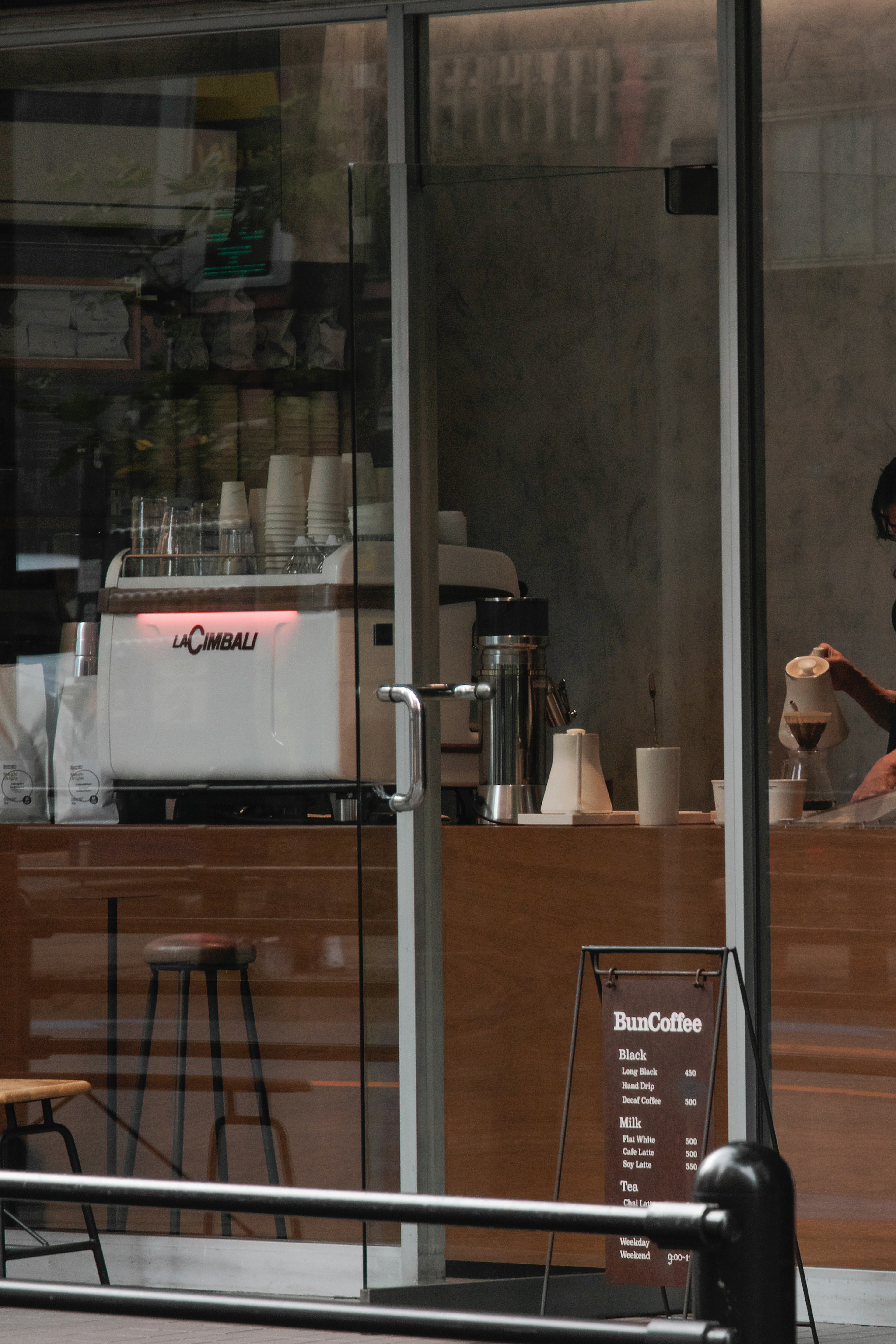 Barista preparing coffee visible through a cafe window