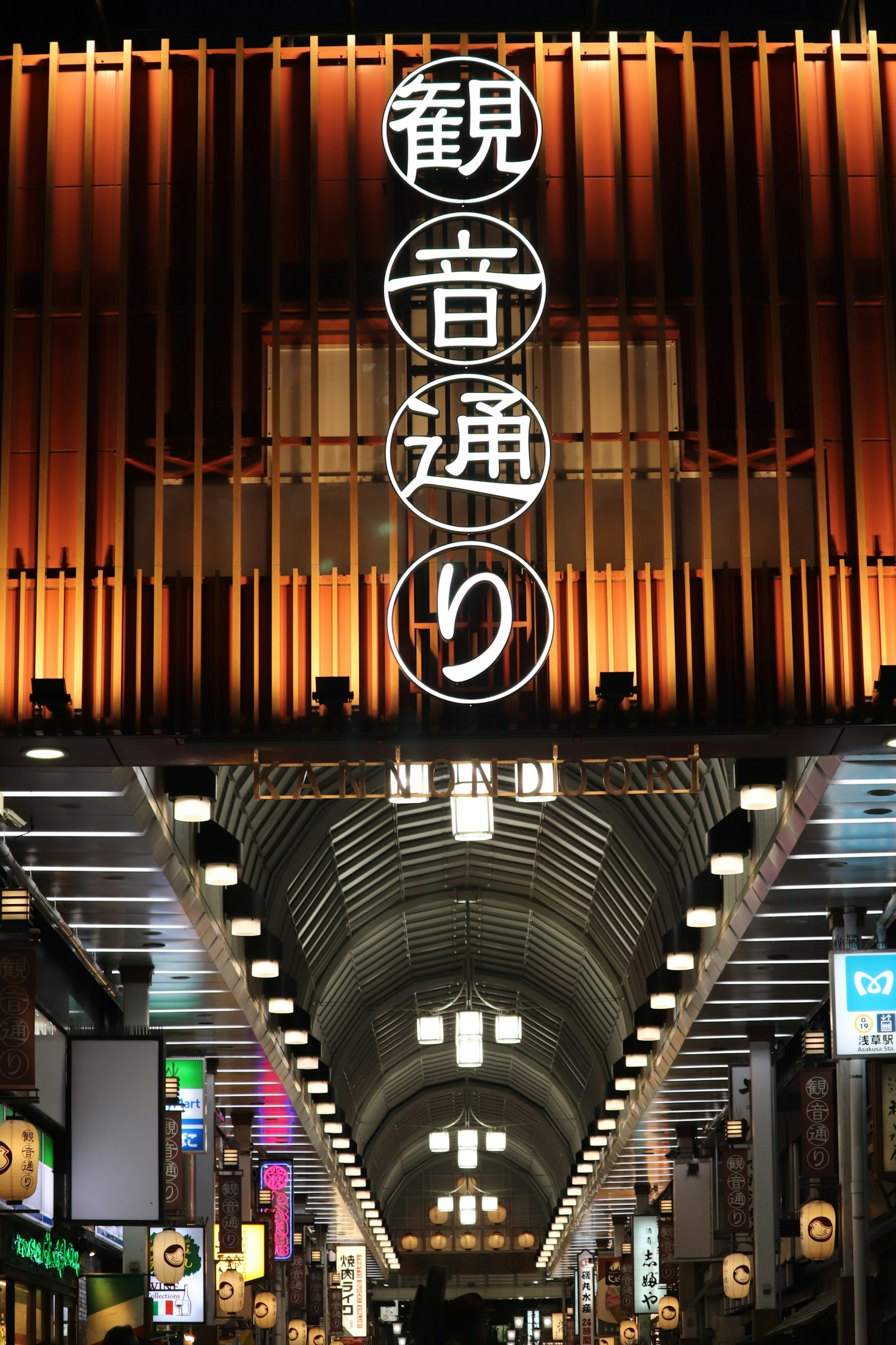 Vue nocturne mettant en avant l'arcade illuminée de la rue Kannon