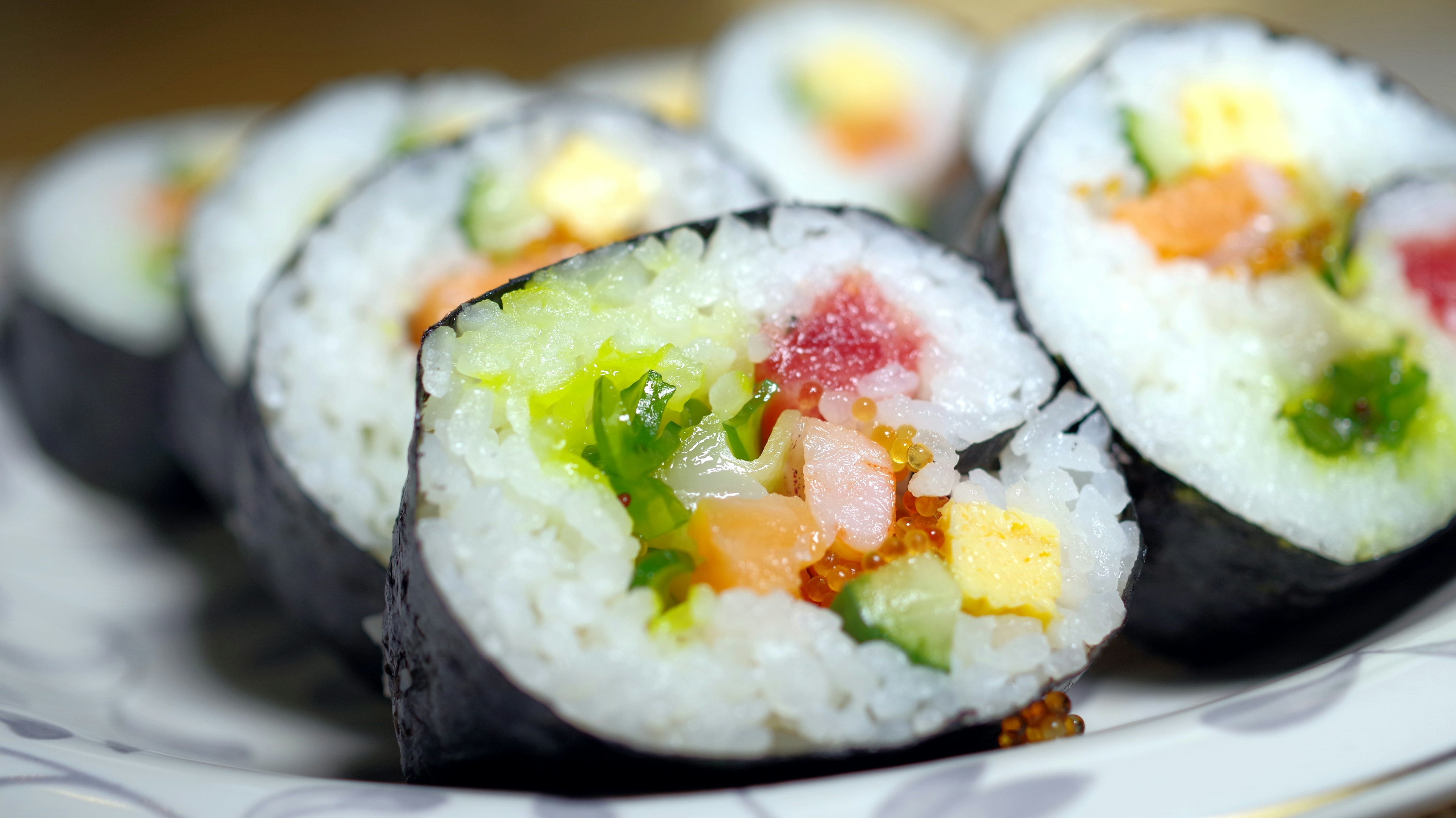 Cuộn sushi với các nguyên liệu đầy màu sắc được bày trên đĩa