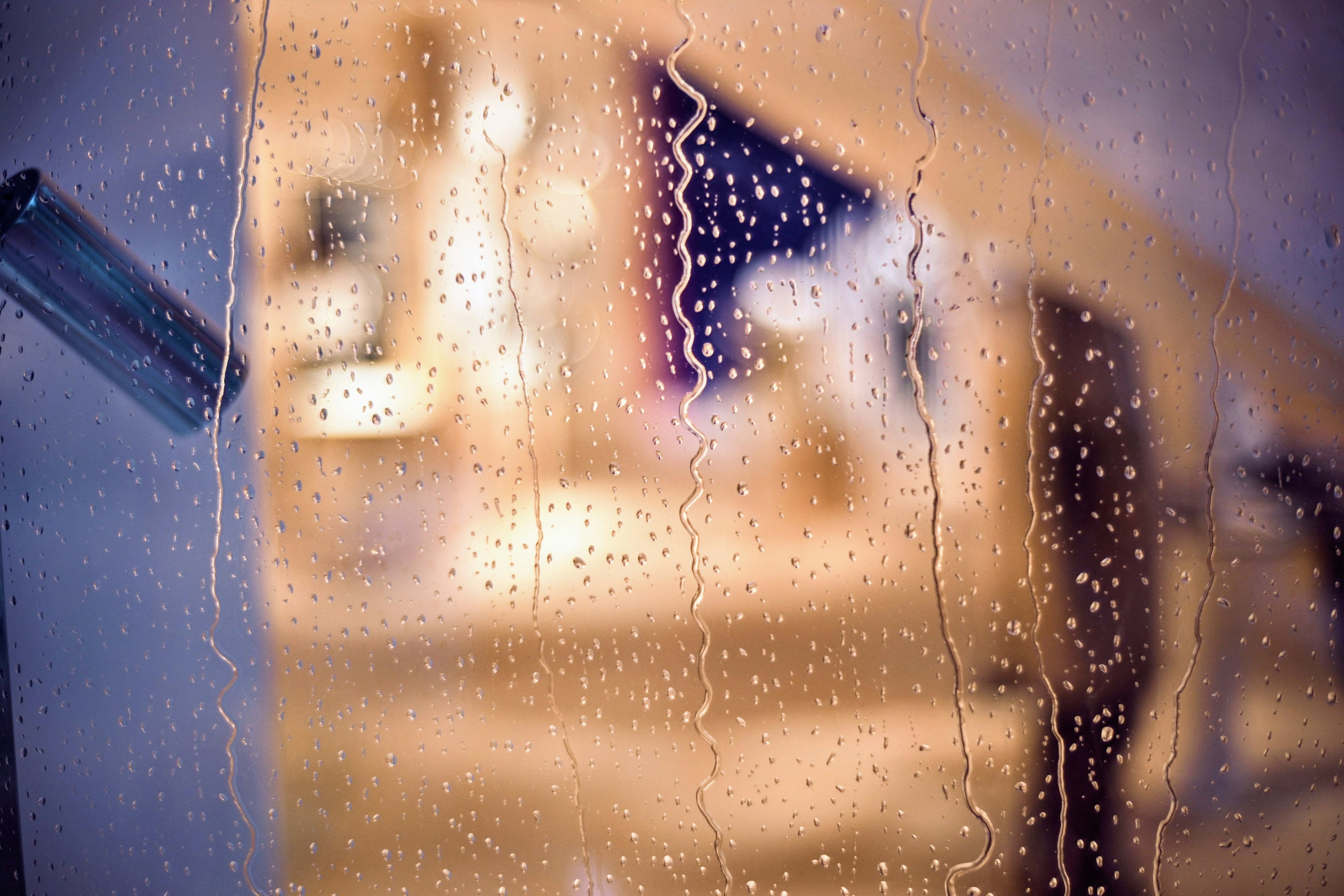 透过雨水浸湿的窗户看到的模糊背景和水滴