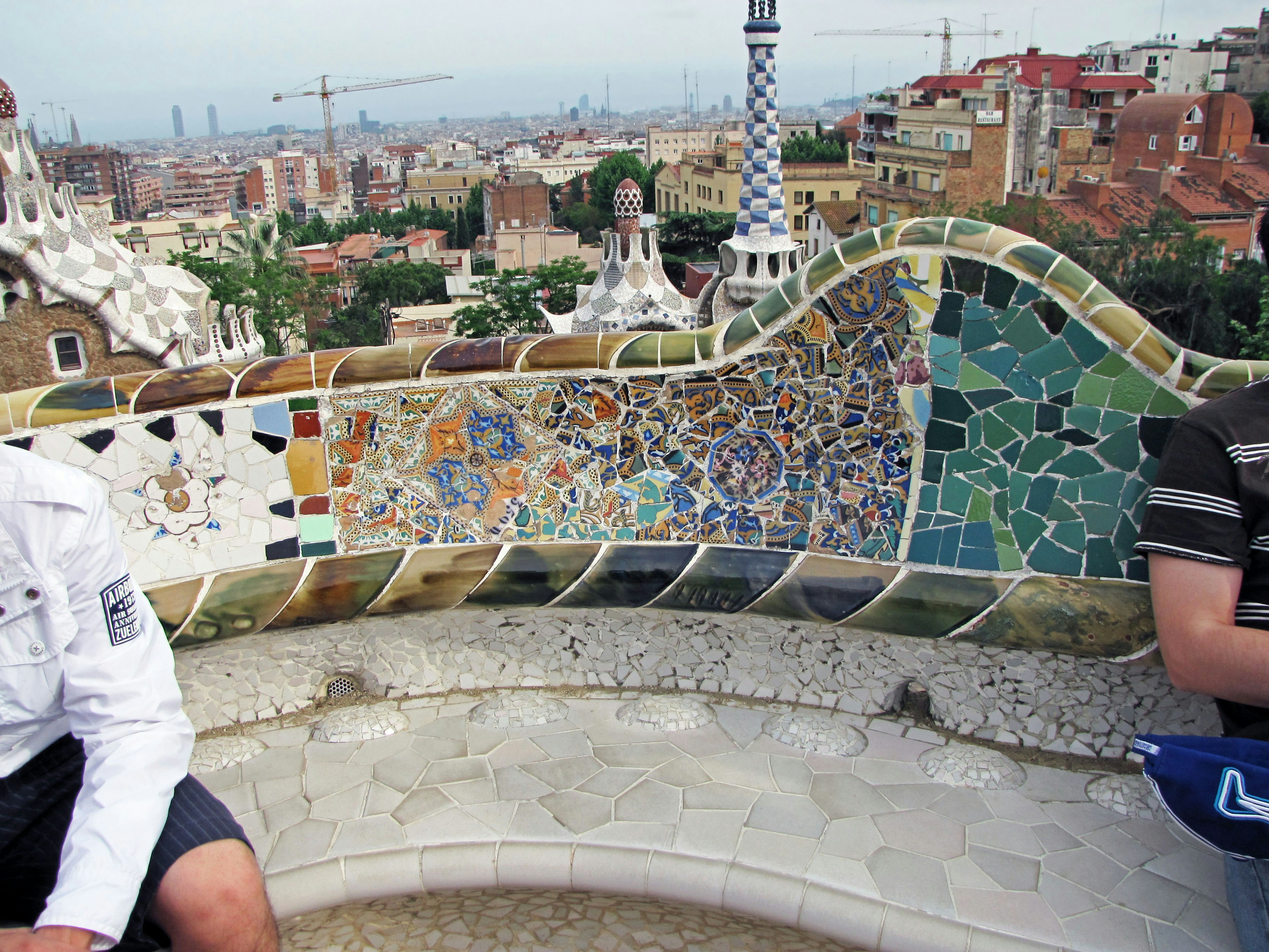 Colorful mosaic bench at Park Güell in Barcelona with a city view