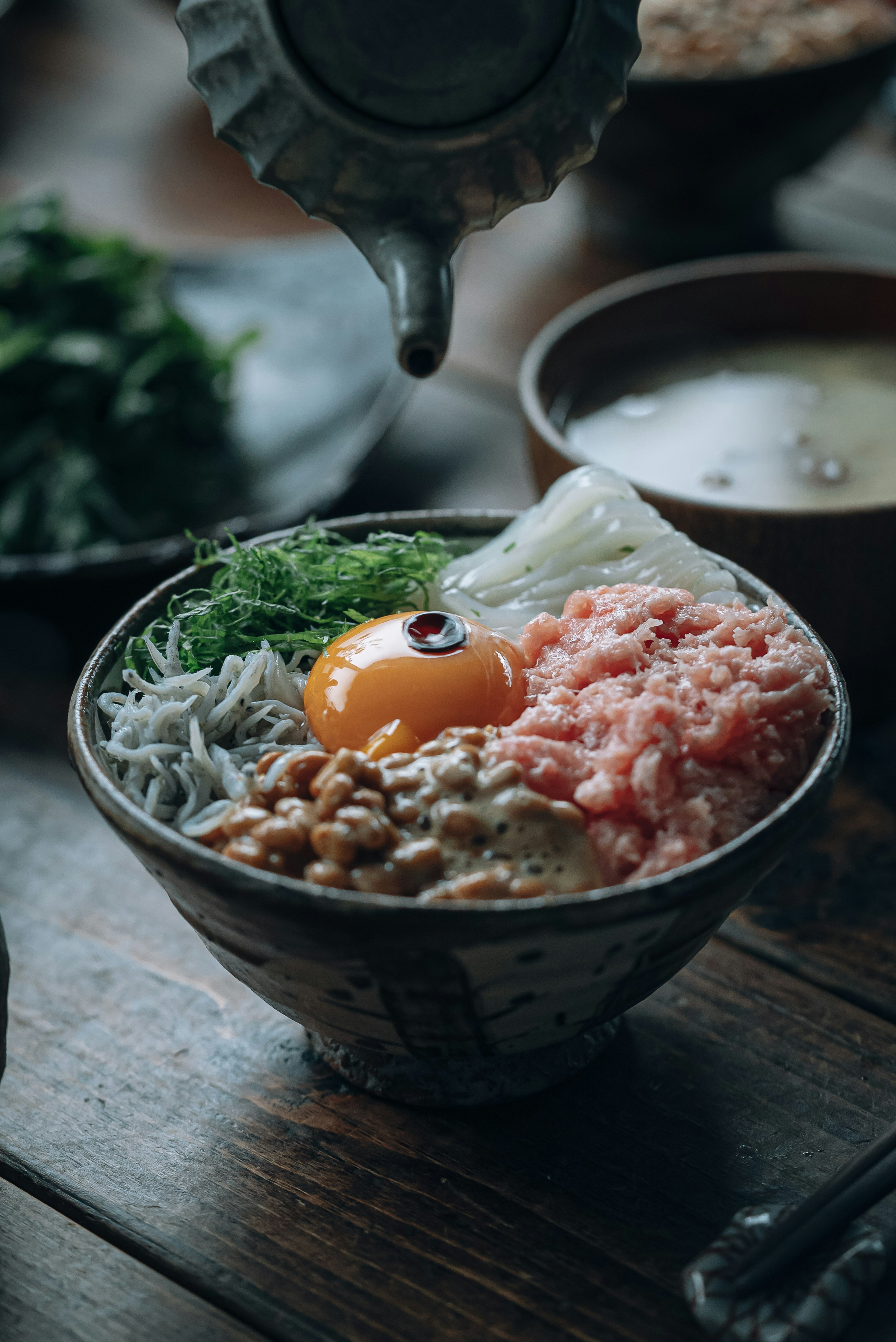 新鮮な卵と生の魚の切り身が載った丼料理