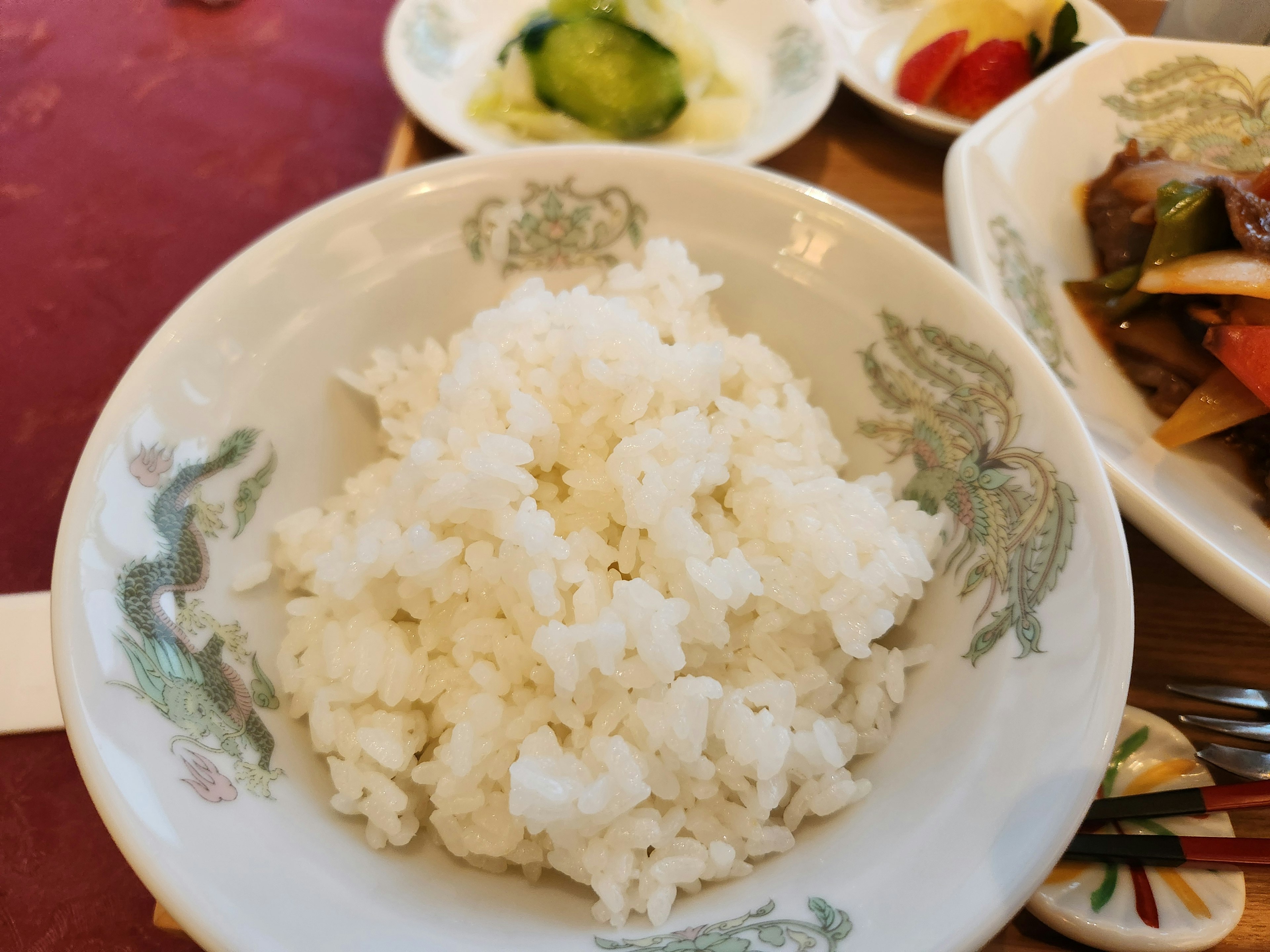 Bowl of white rice with surrounding dishes