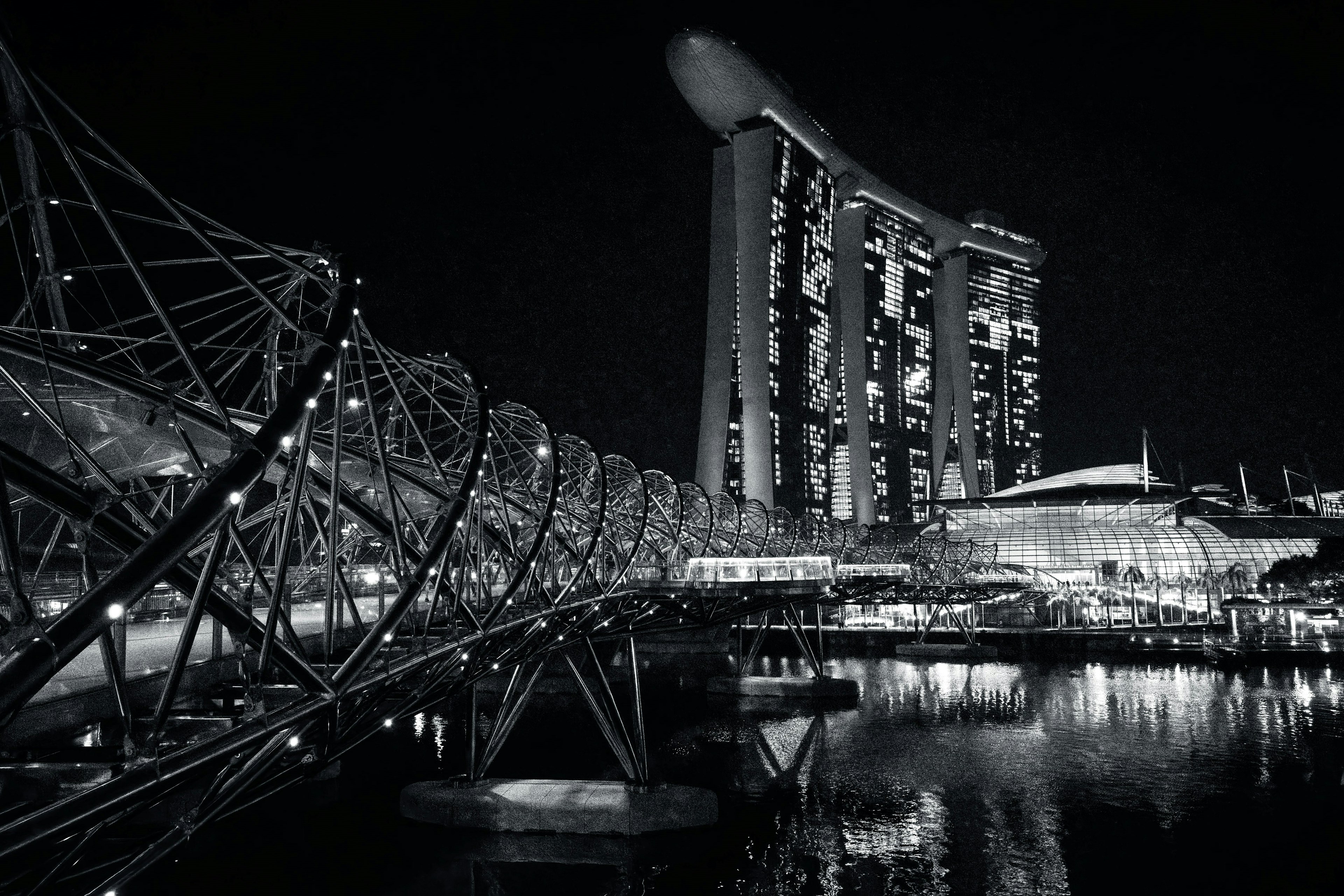 Foto en blanco y negro del horizonte de Singapur con Helix Bridge y Marina Bay Sands