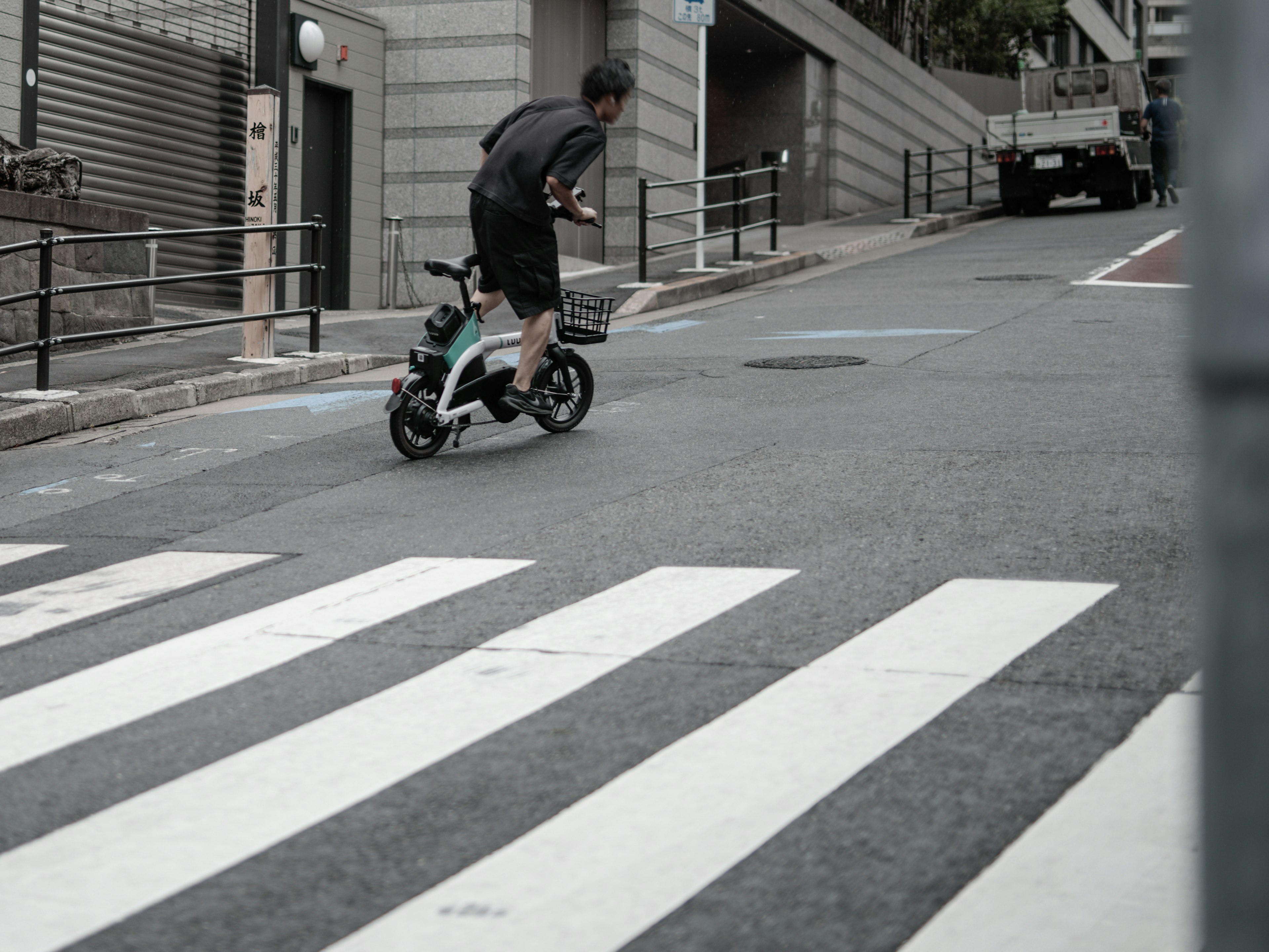 Man riding a bicycle down a sloped street