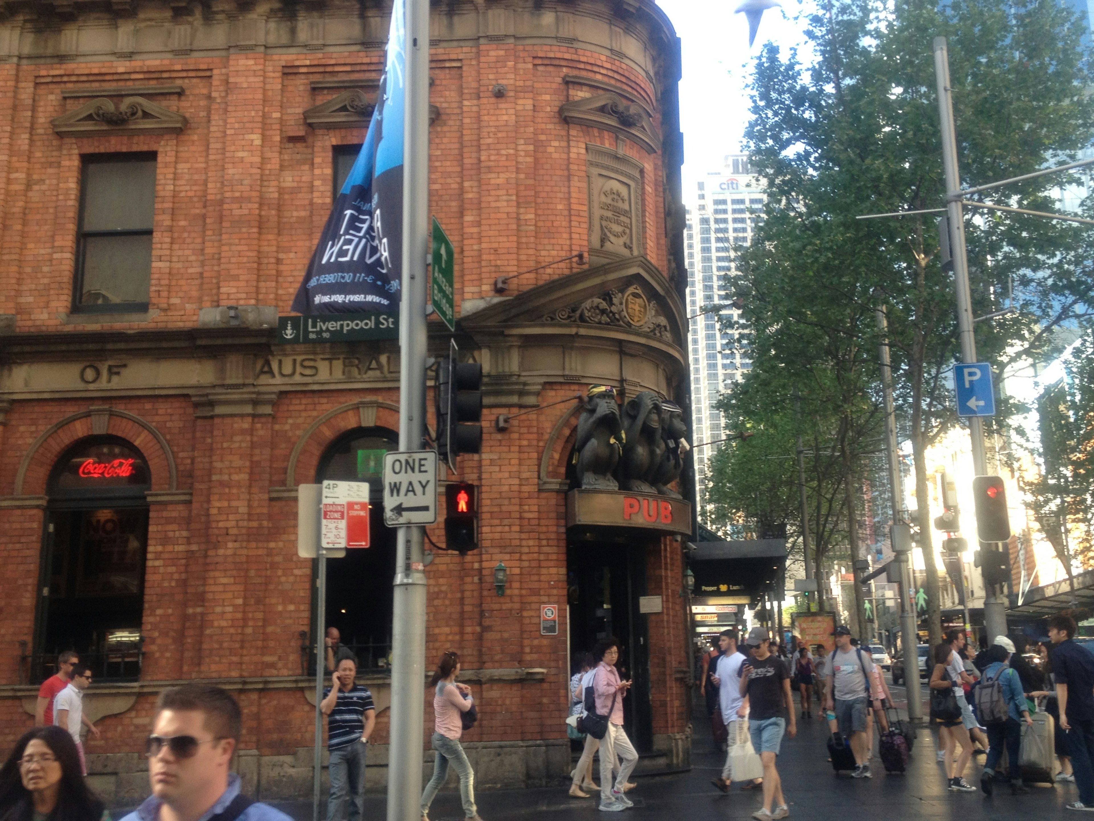 Historic red brick building with people walking by in a busy street scene in Sydney