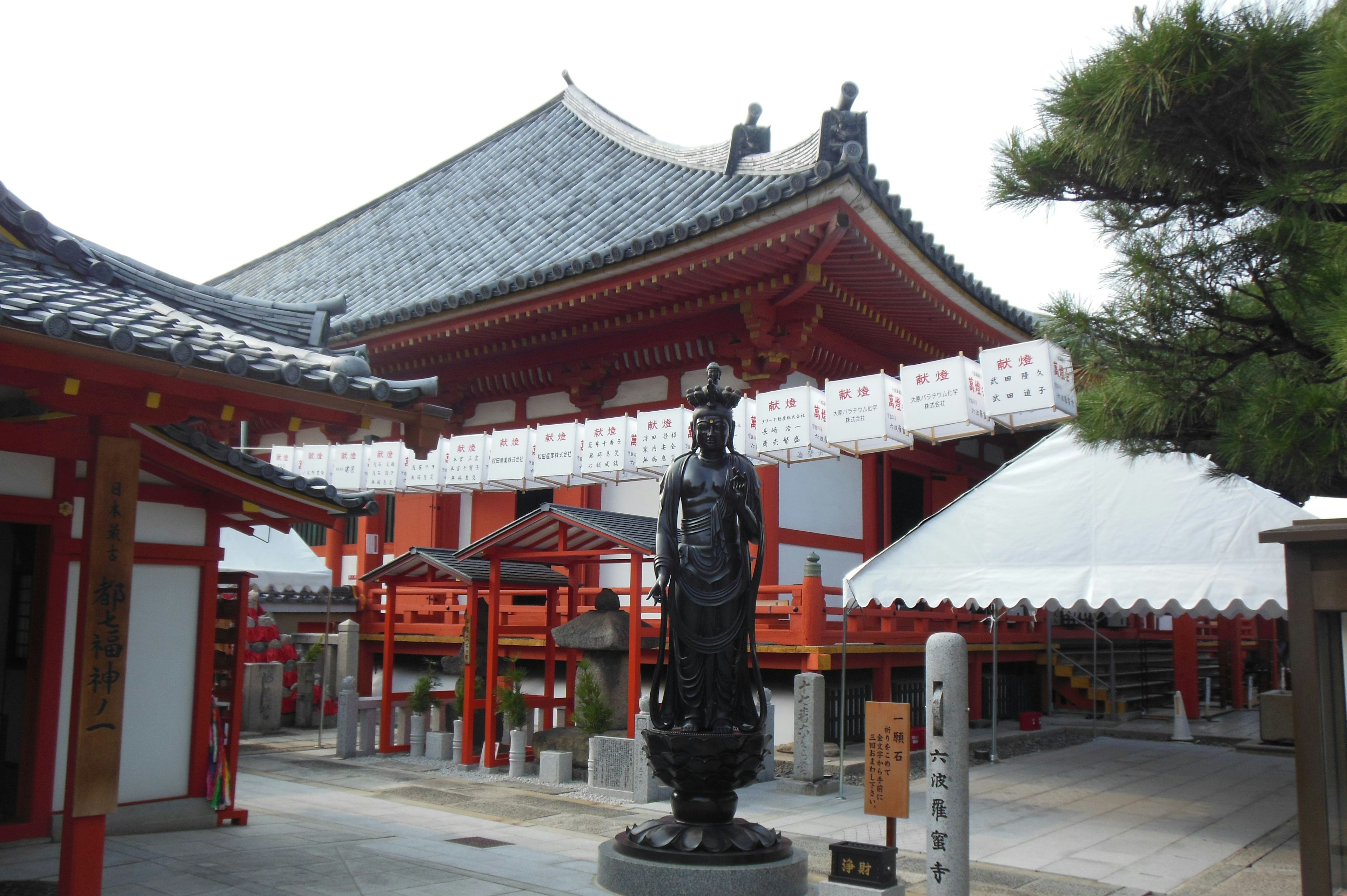 Arquitectura de un templo japonés con una estatua negra en primer plano