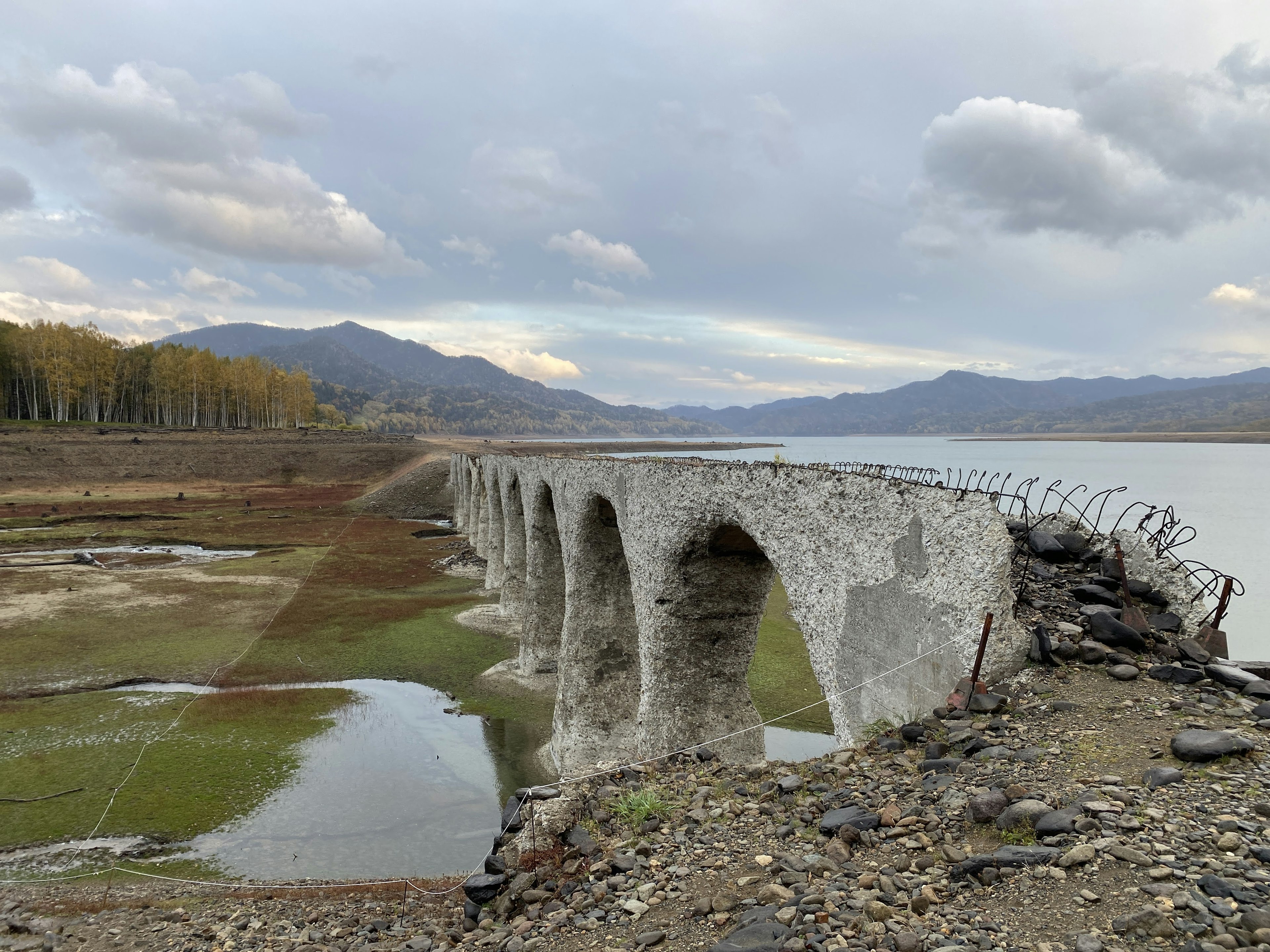 Antigua estructura de puente de piedra cerca de un lago seco