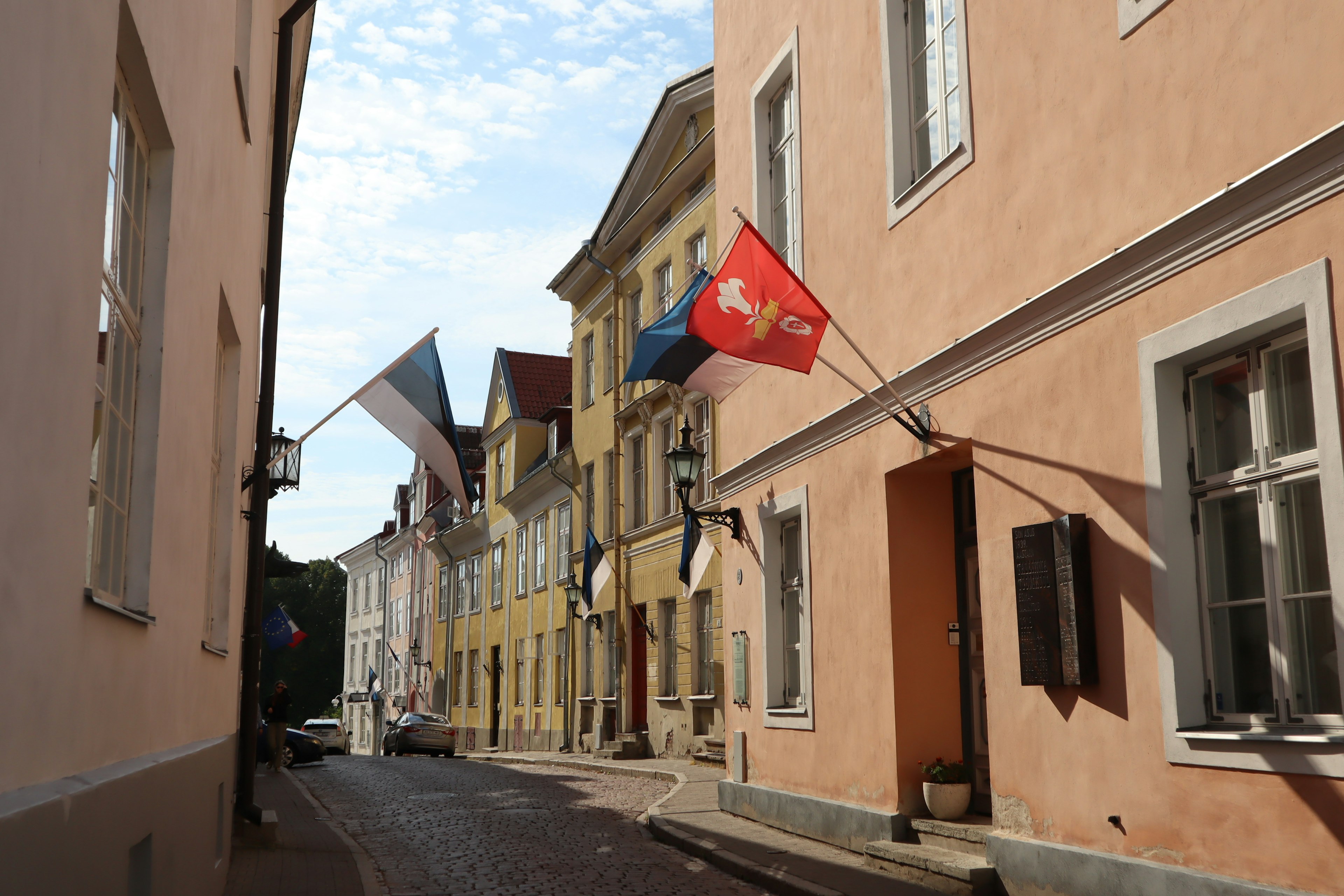 Strada stretta fiancheggiata da edifici colorati e bandiere esposte