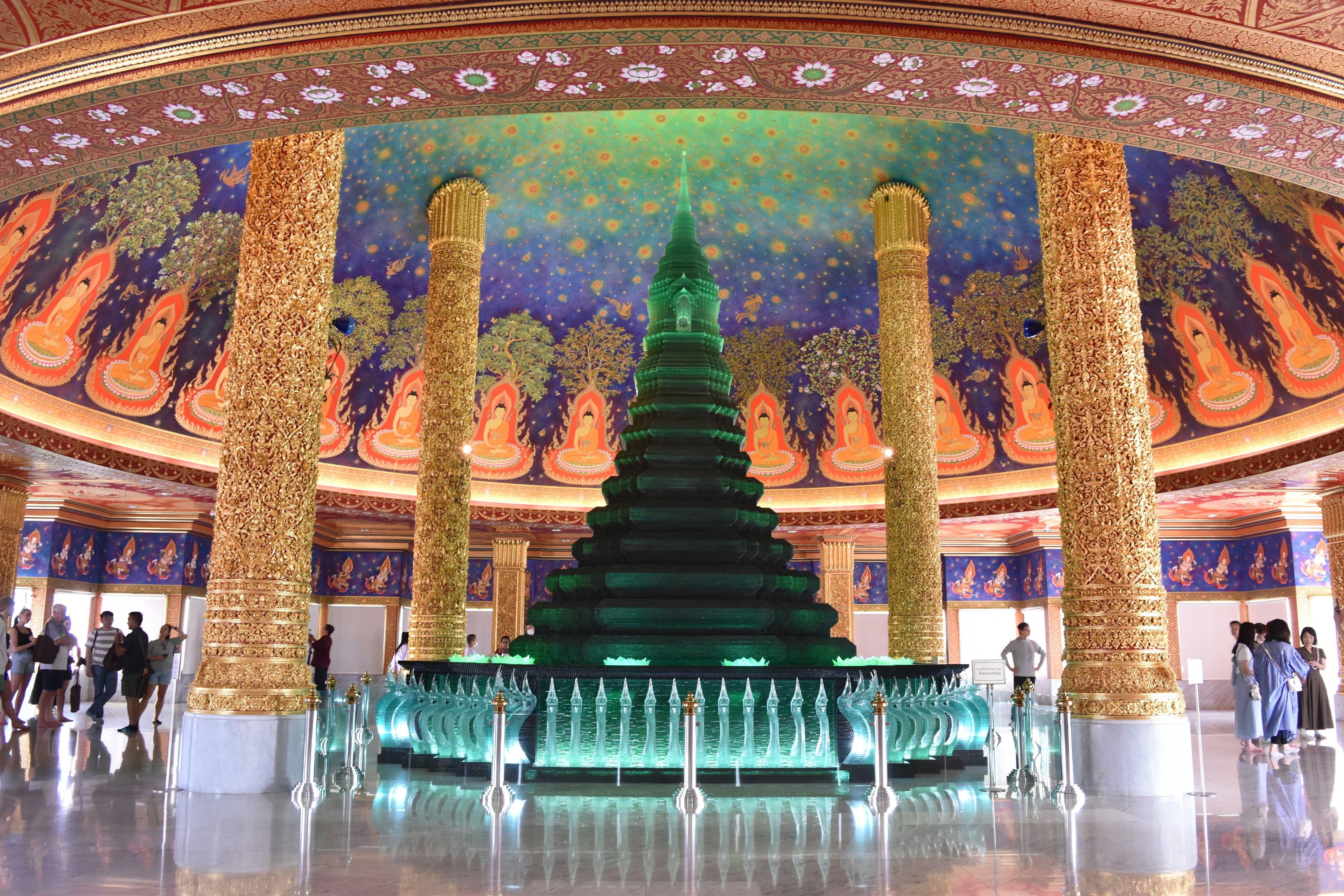 Green Buddhist stupa with fountains under a beautifully decorated dome ceiling