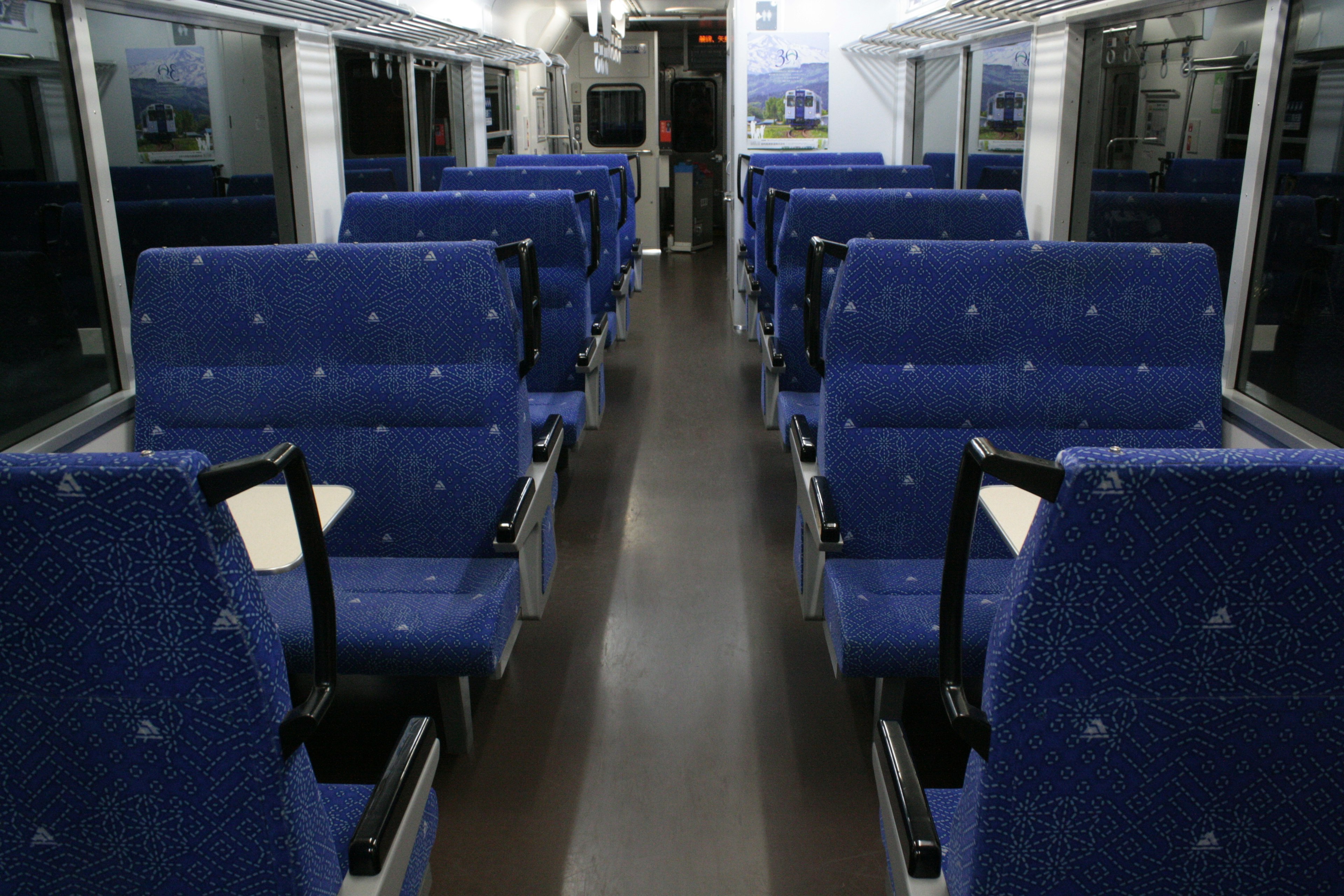 Interior of a train carriage with blue seats