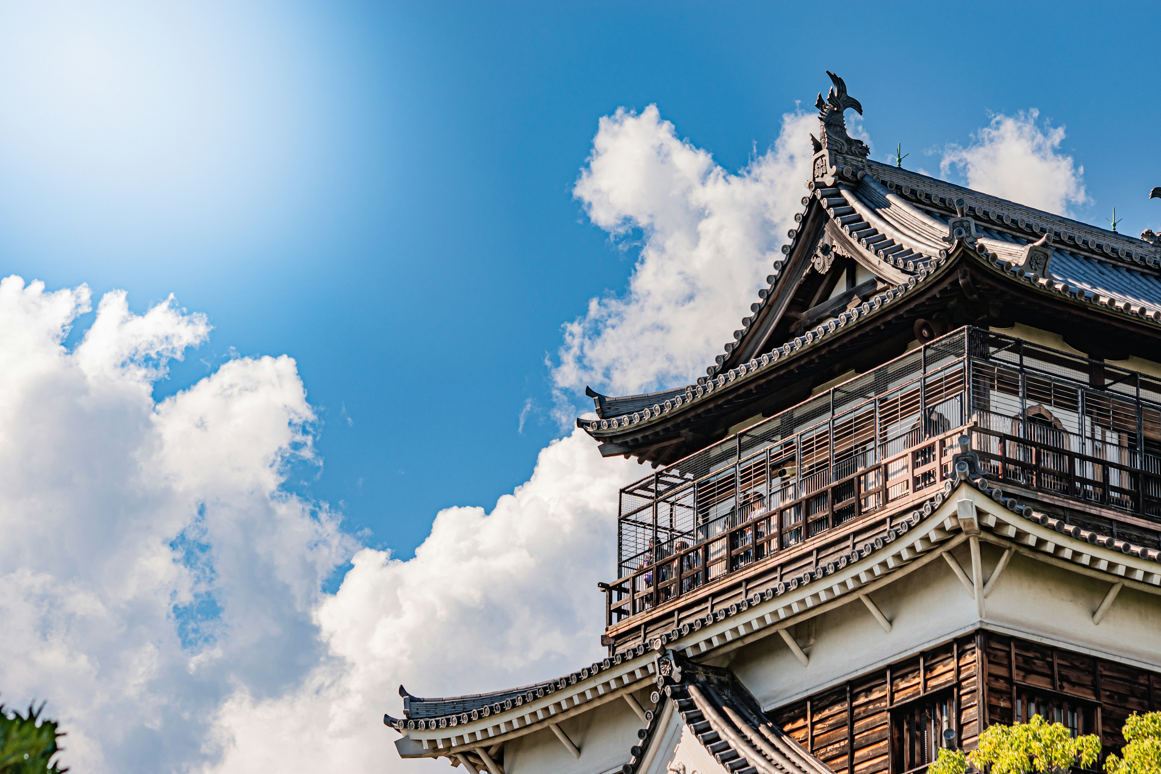 Part of a traditional Japanese castle under a clear blue sky