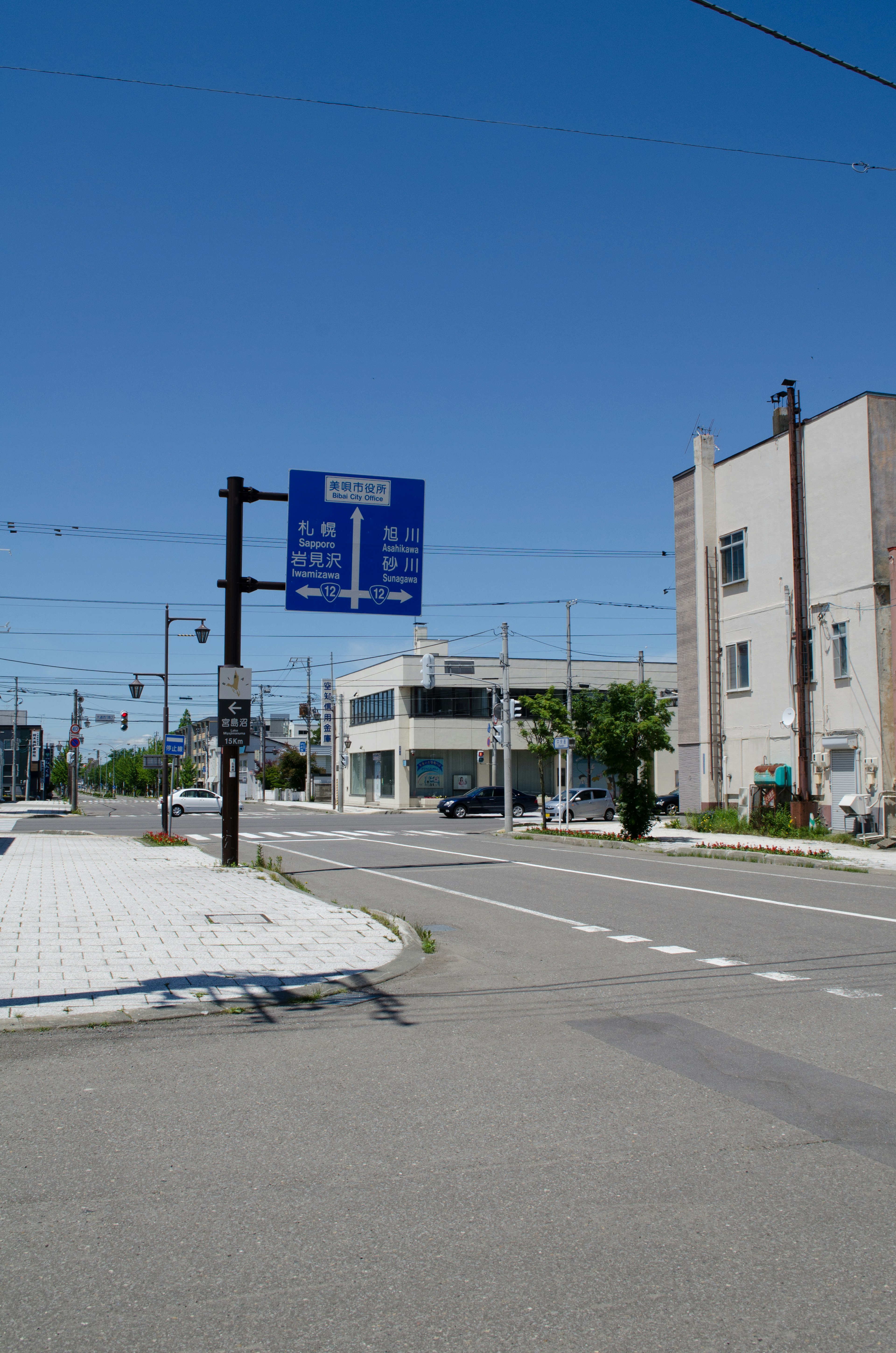 Road sign and buildings under a clear blue sky