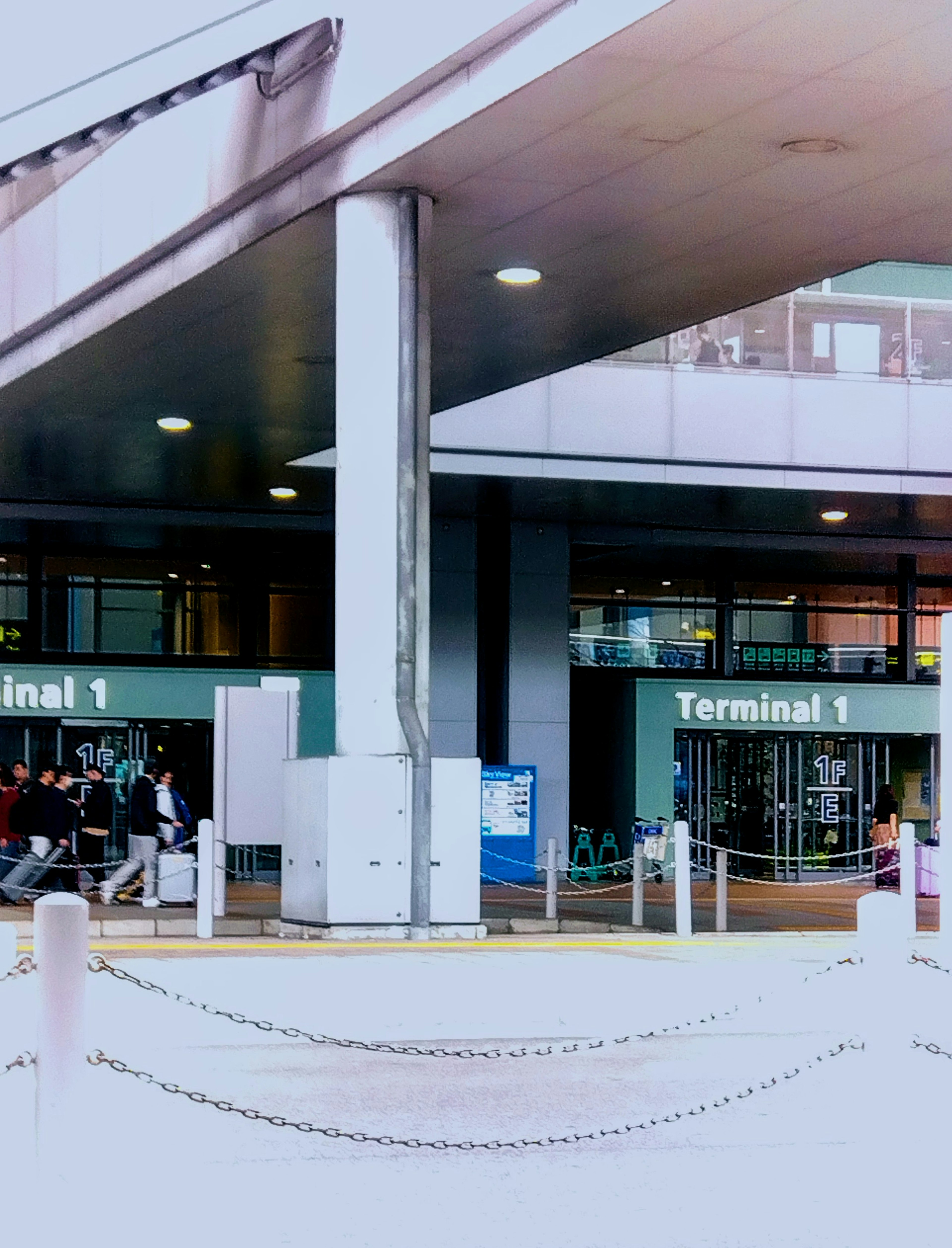 Entrance of Airport Terminal 1 with passengers waiting