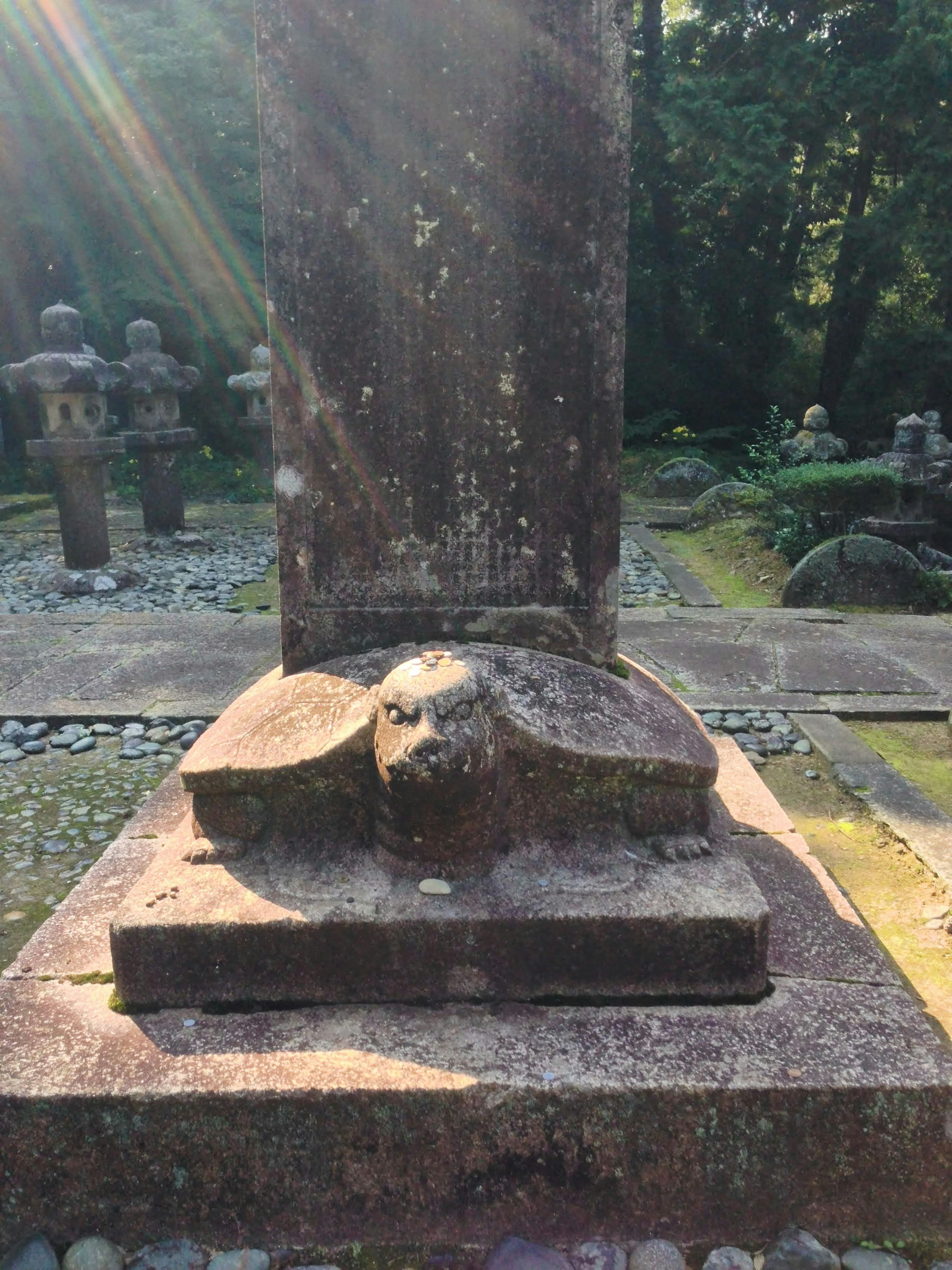 An ancient sculpture base with a stone tablet illuminated by sunlight