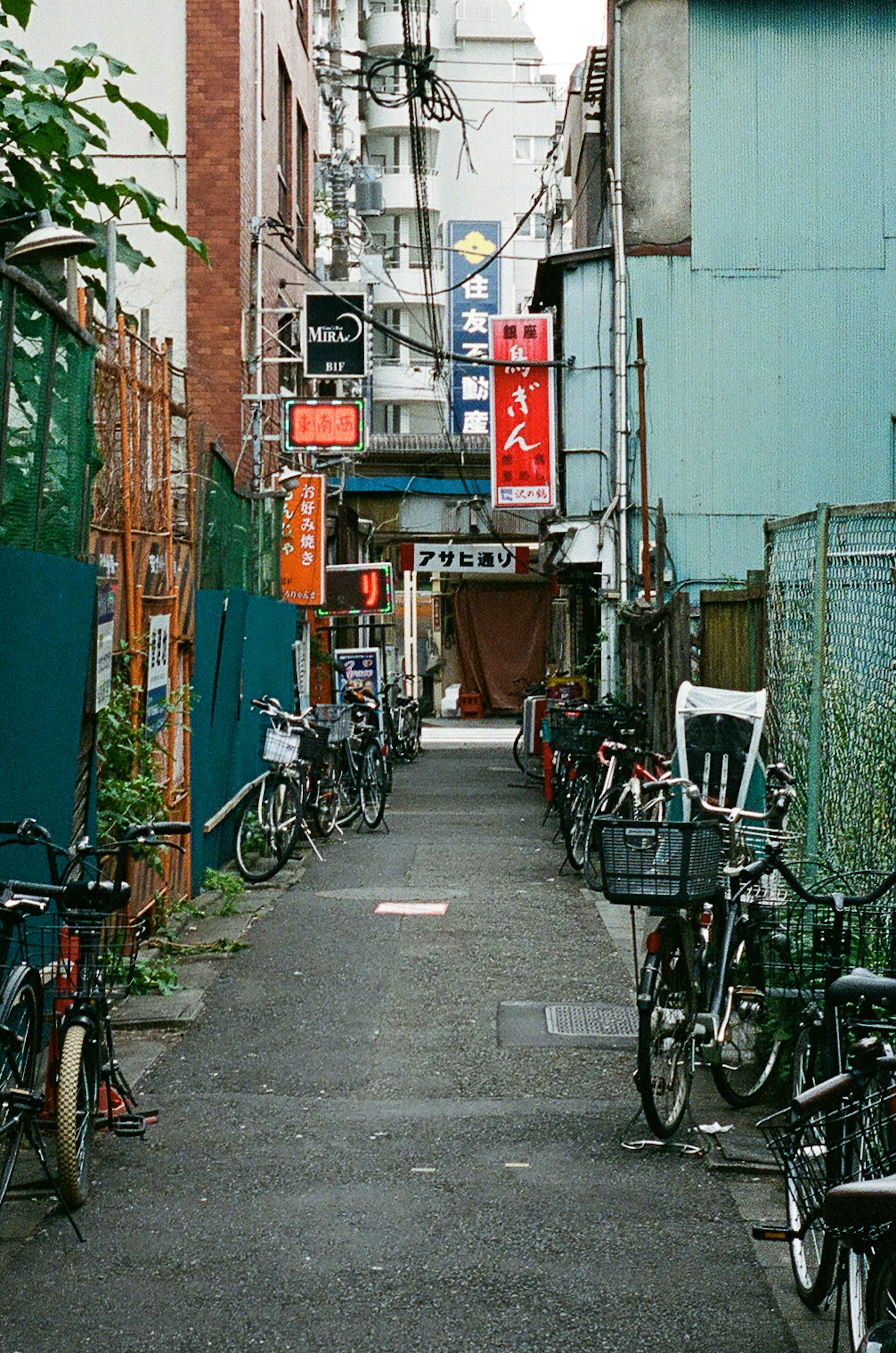 Narrow alley lined with bicycles and colorful signs