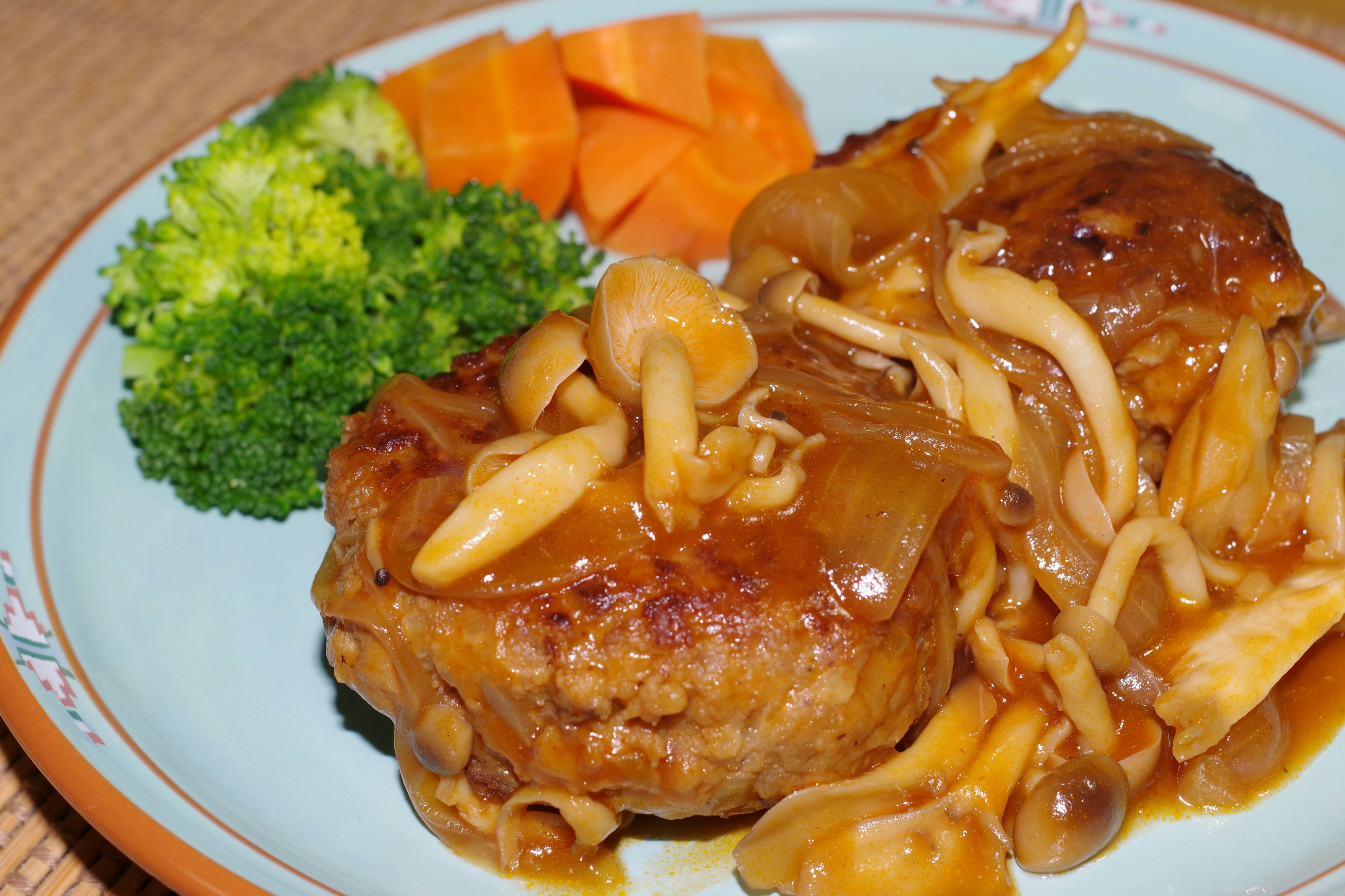 Leckeres Hamburgersteak mit Pilzsauce serviert mit Brokkoli und Karotten