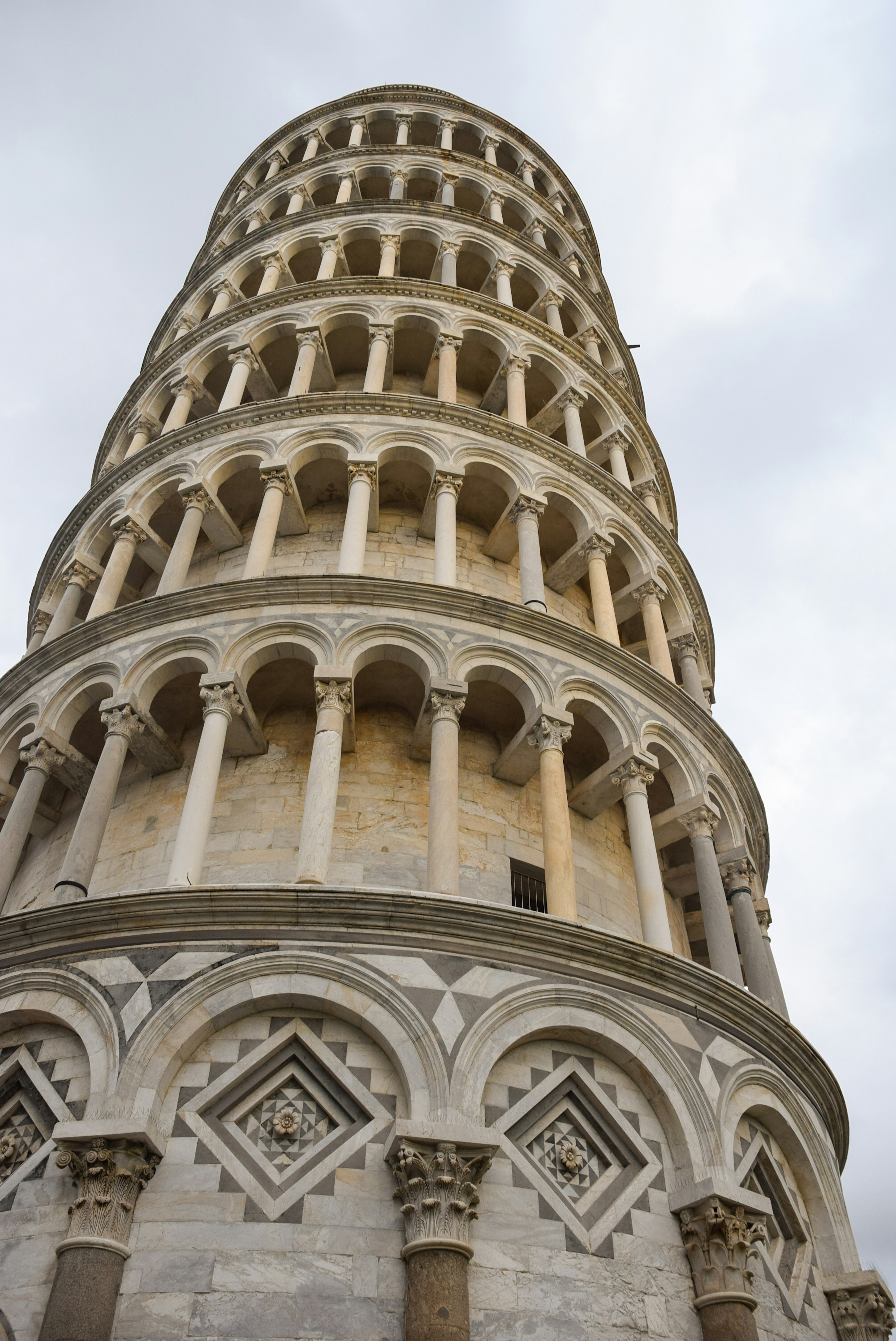 Leaning Tower of Pisa captured from a low angle showcasing its Romanesque architectural details