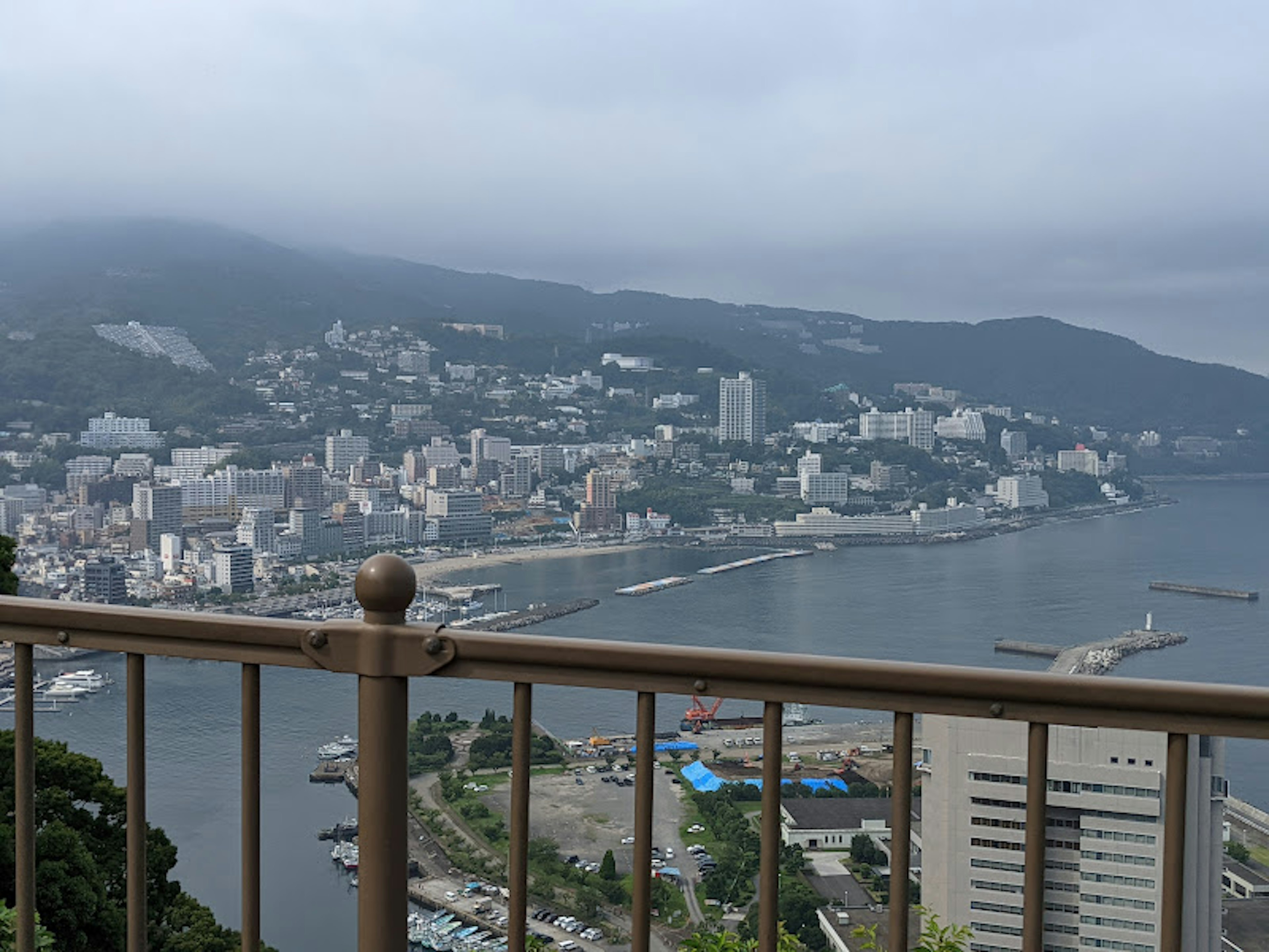 Stadtansicht mit Bergen und Küste unter bewölktem Himmel