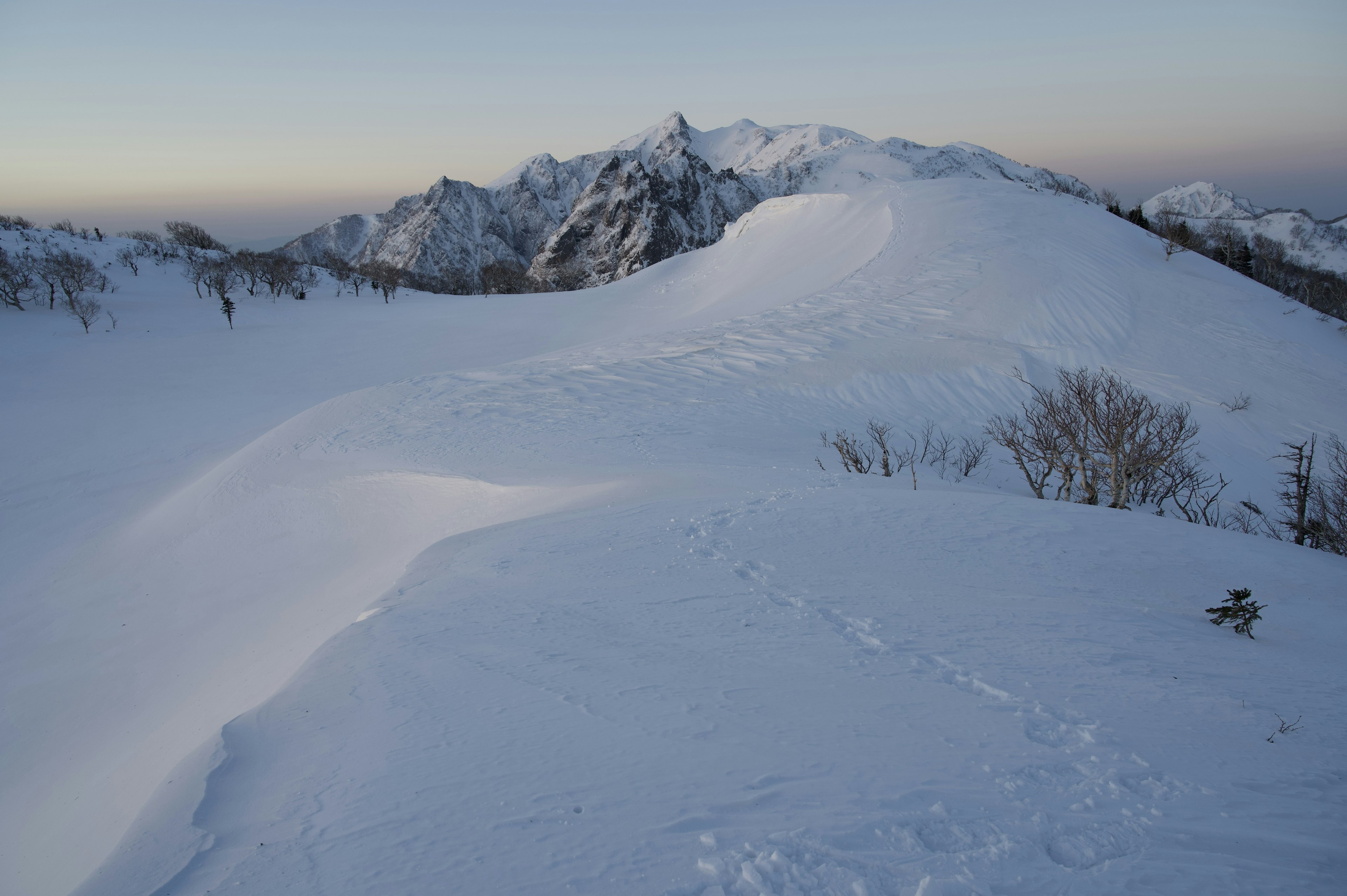 Snow-covered mountain landscape with a dusk sky