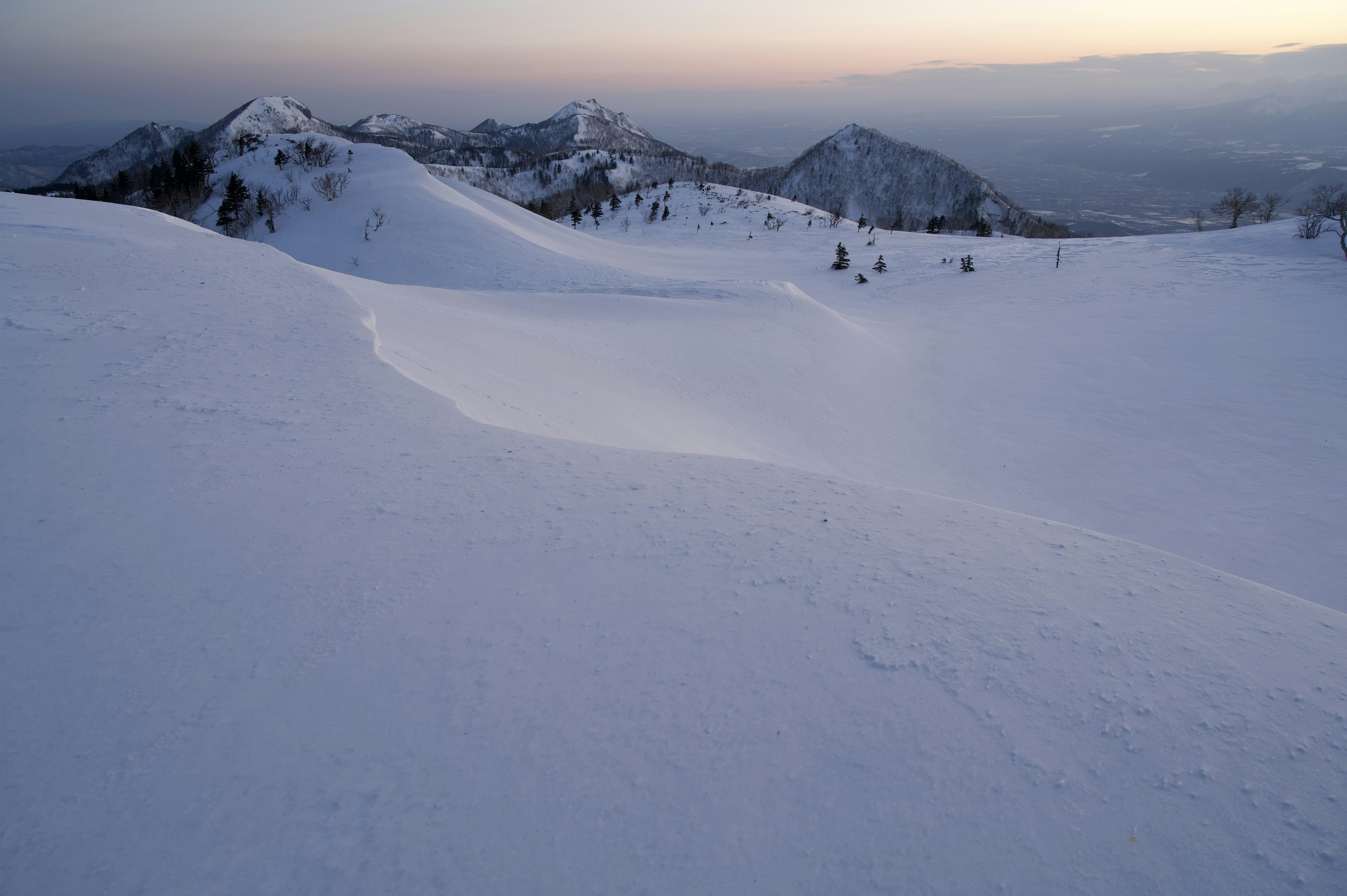 Paesaggio montano coperto di neve con cielo crepuscolare