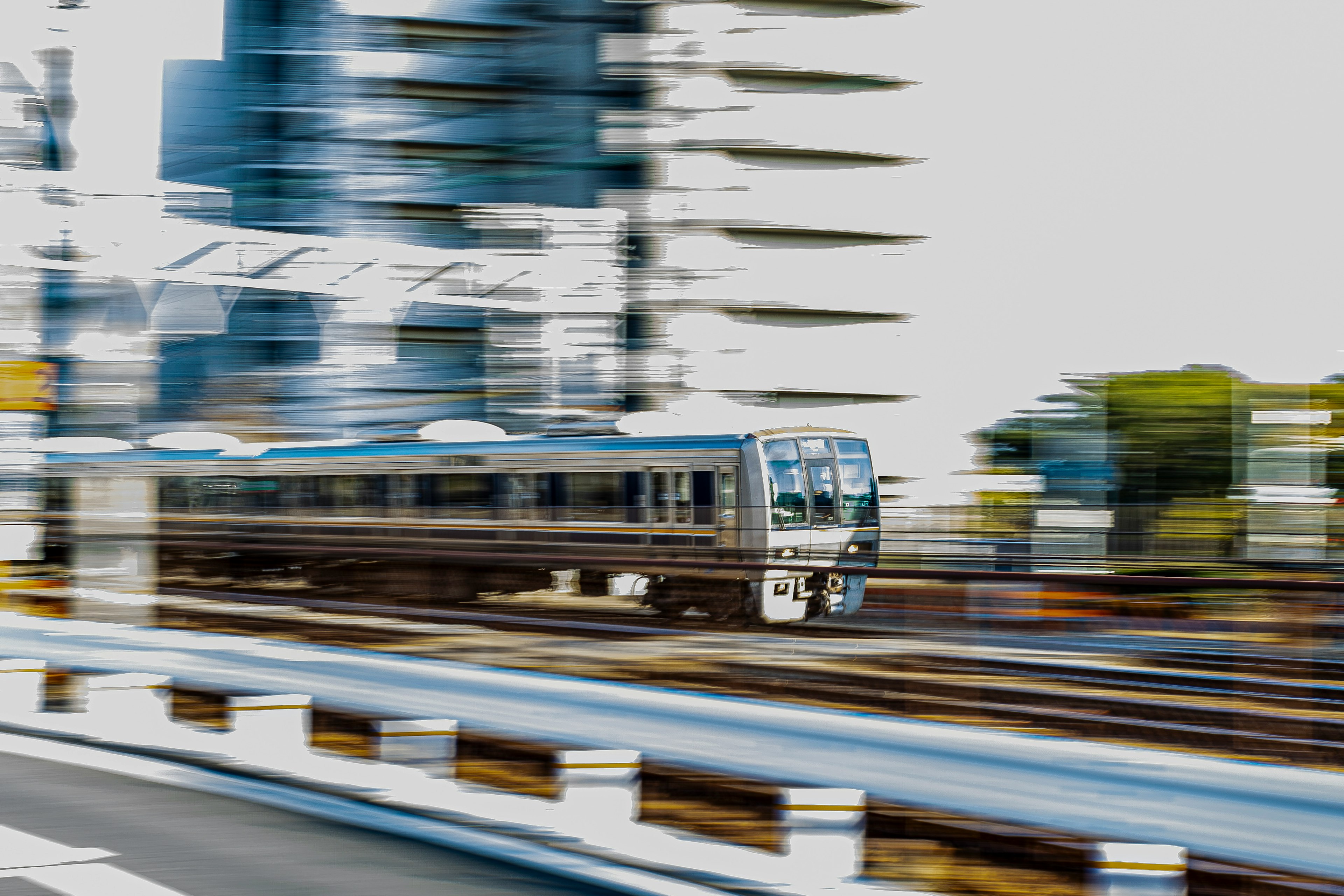 Blurry train in motion alongside modern skyscrapers