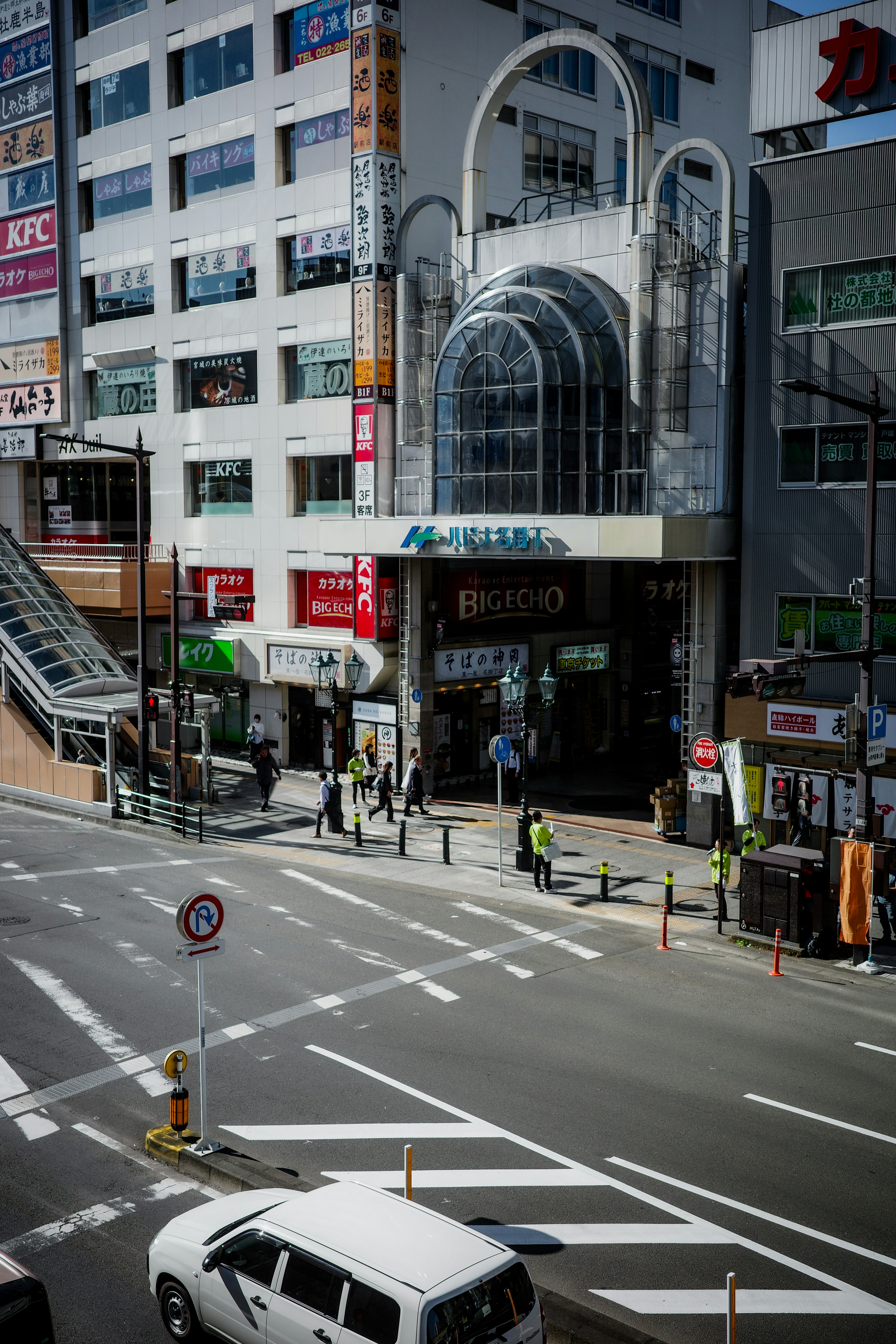 Vue d'une entrée de bâtiment commercial avec une large rue