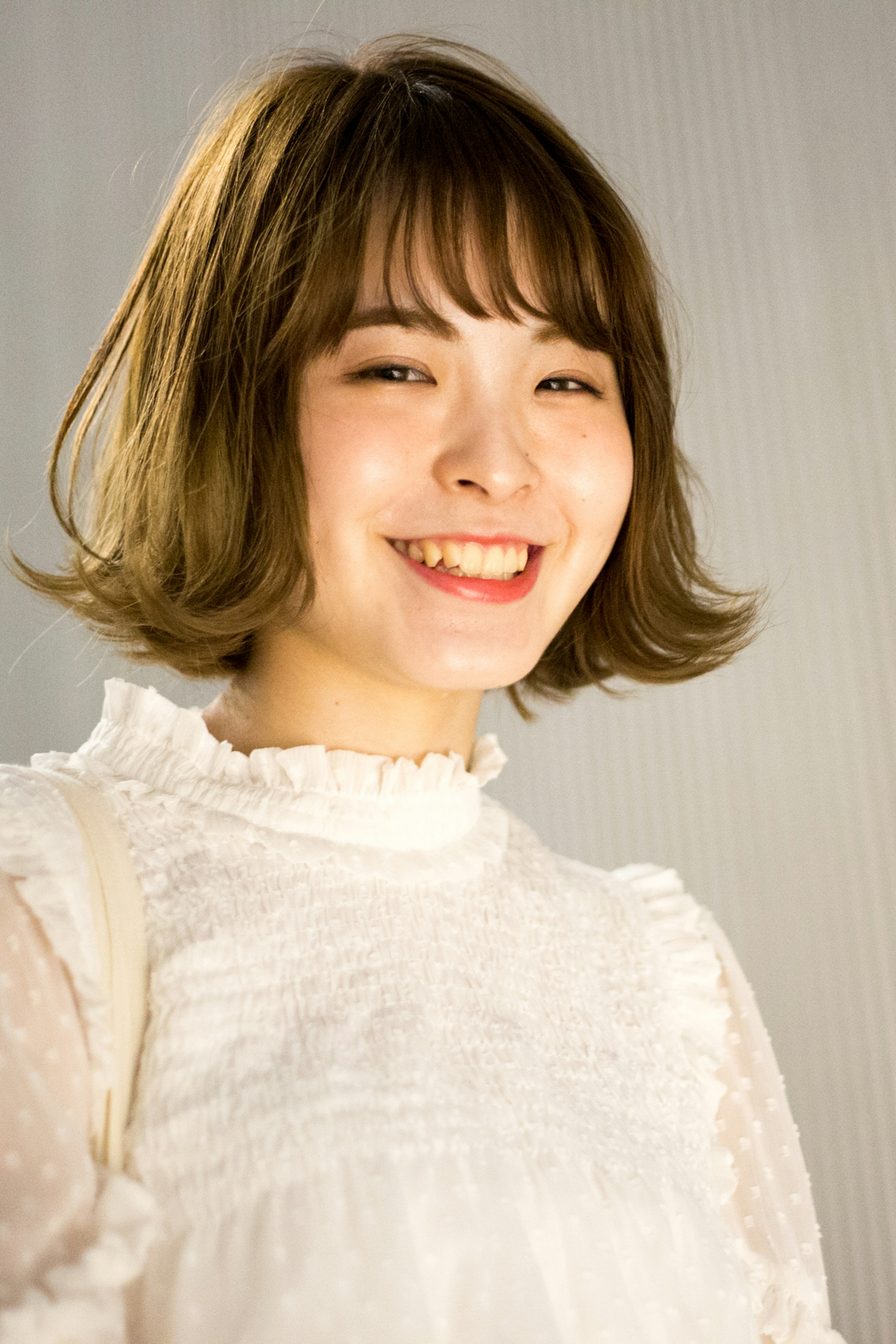 Femme souriante en blouse blanche avec les cheveux courts