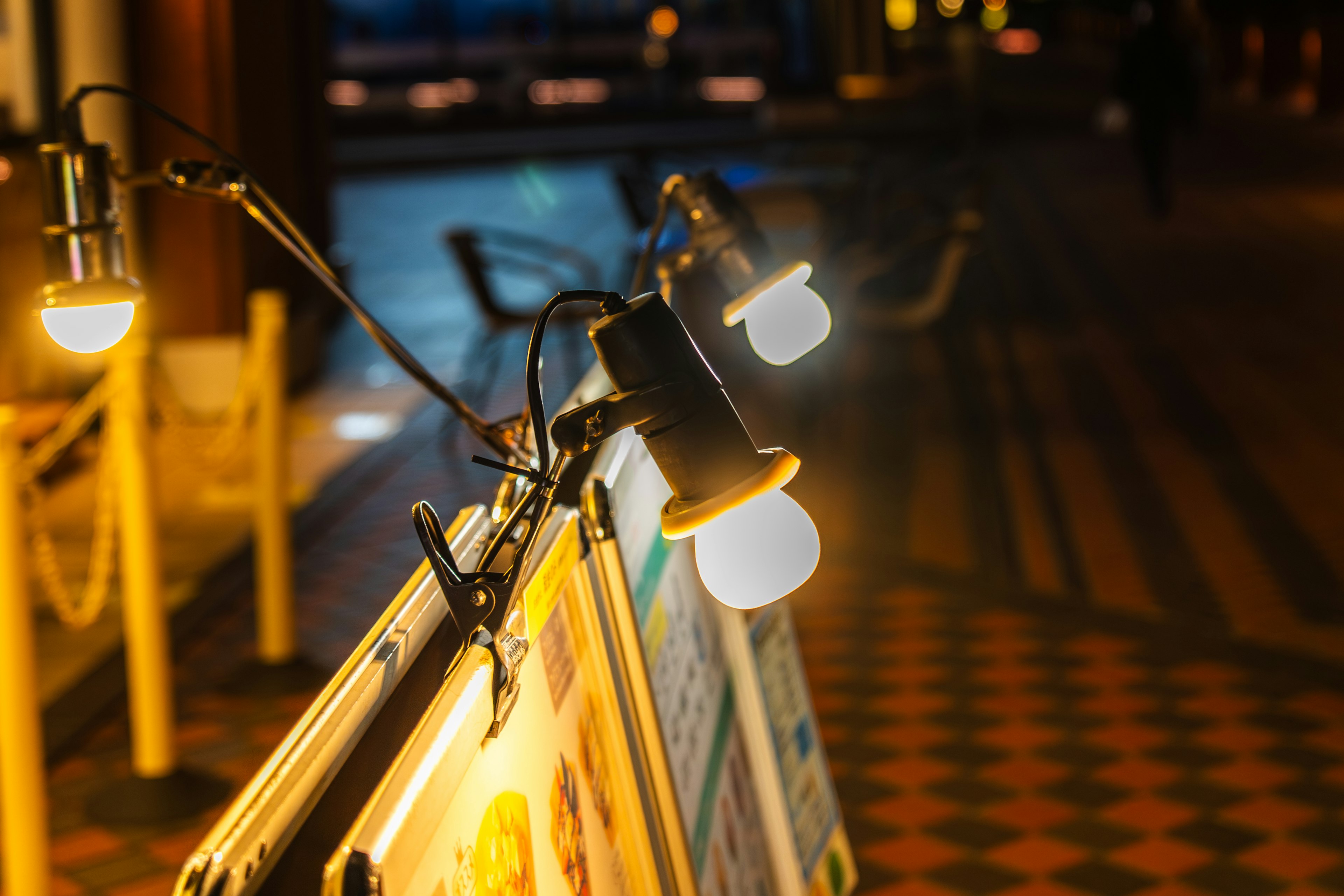 Bright spotlights attached to street signs in a nighttime setting