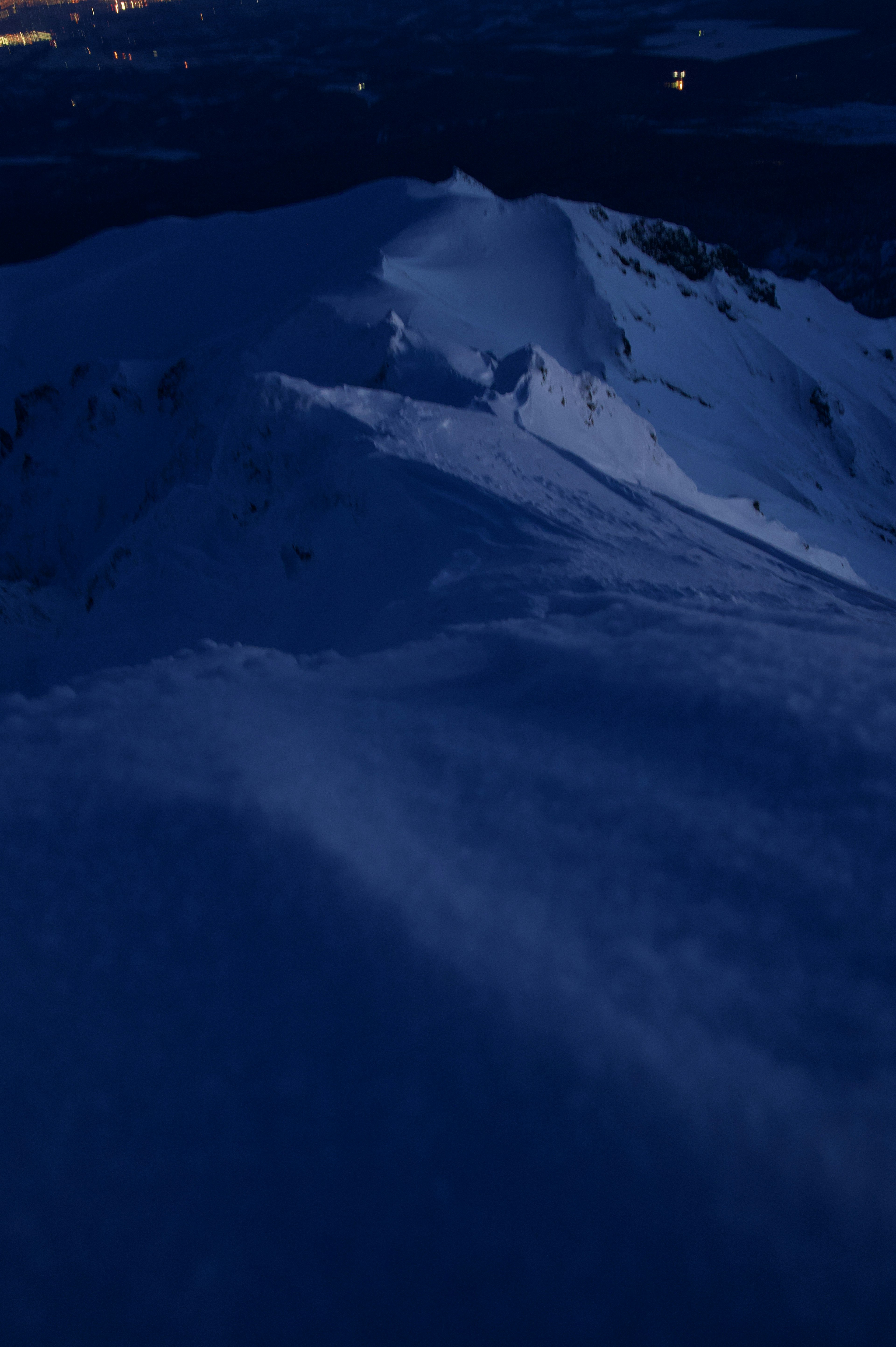 暗い雪山の風景と青いトーンの空