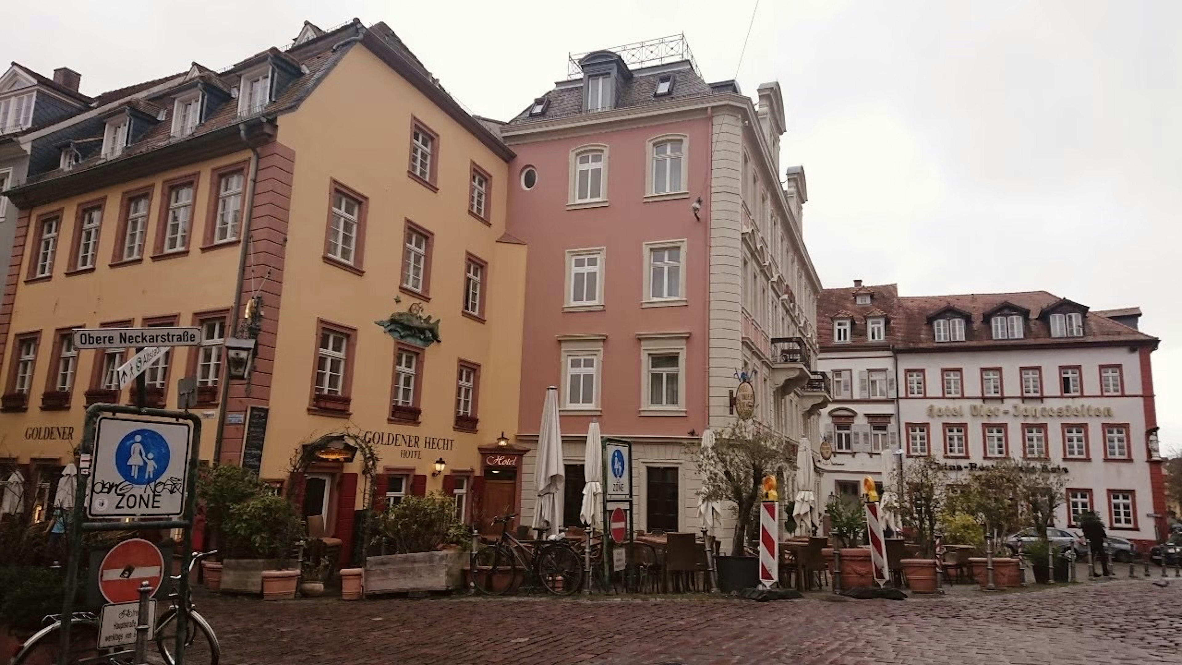 色彩斑斕的建築排列在城市街道上，有咖啡館和餐廳