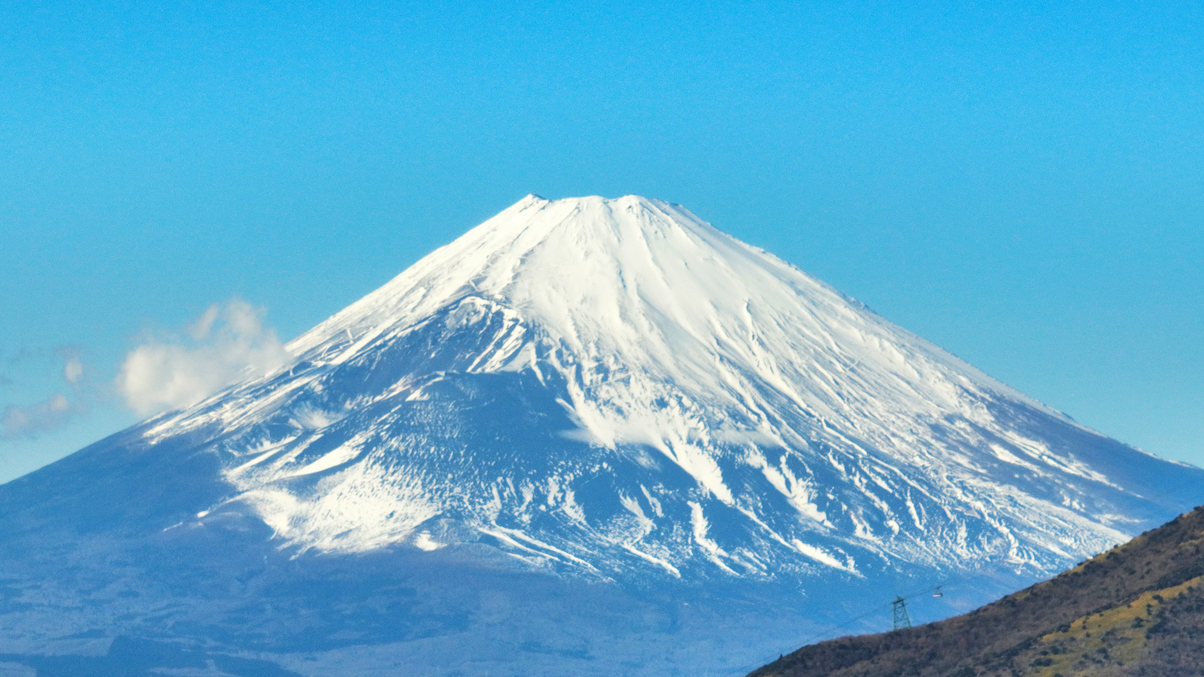 Paesaggio montano innevato con cielo blu chiaro e nuvole