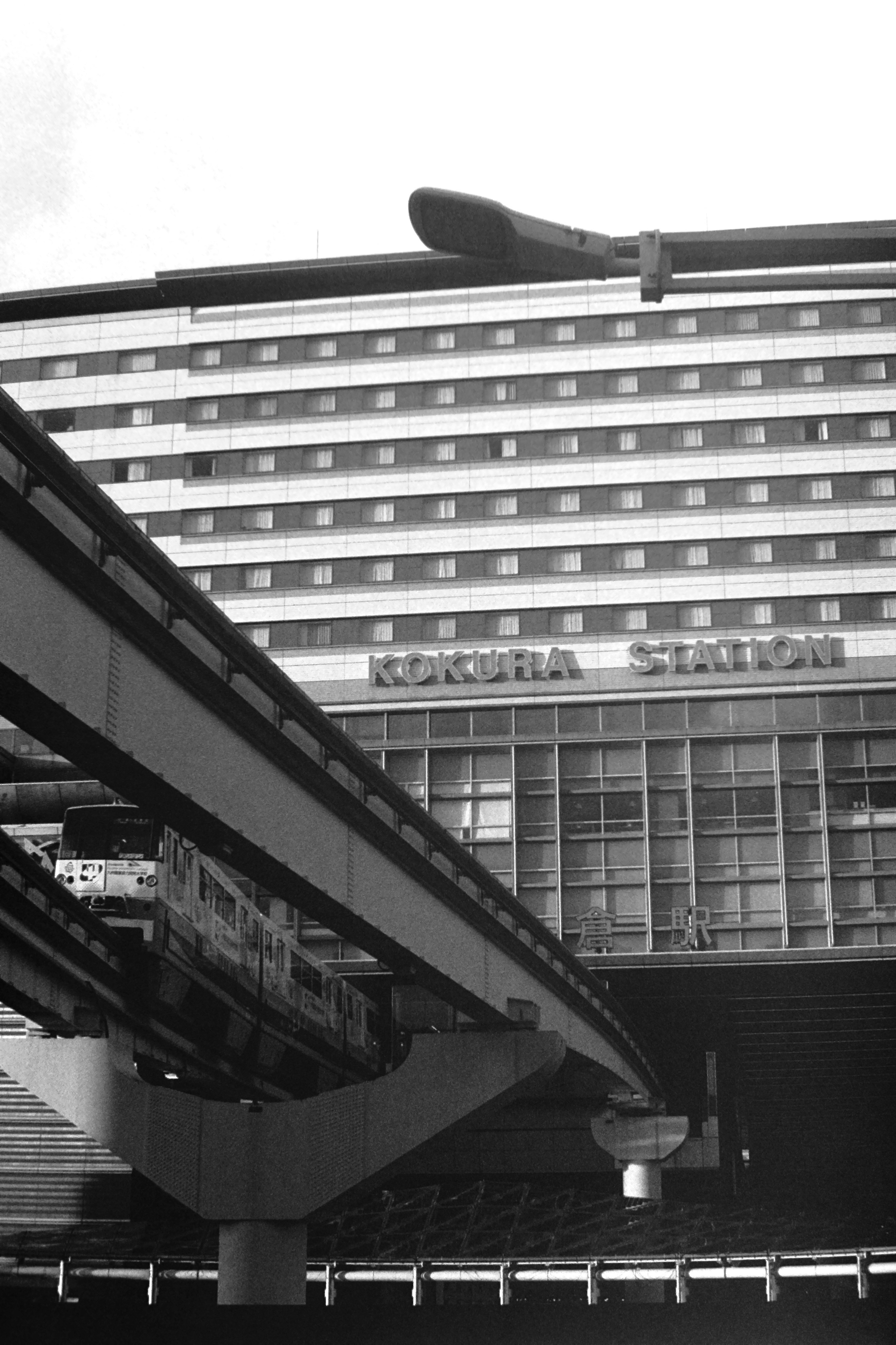 Foto in bianco e nero di un edificio della stazione e di una pista di monorotaia