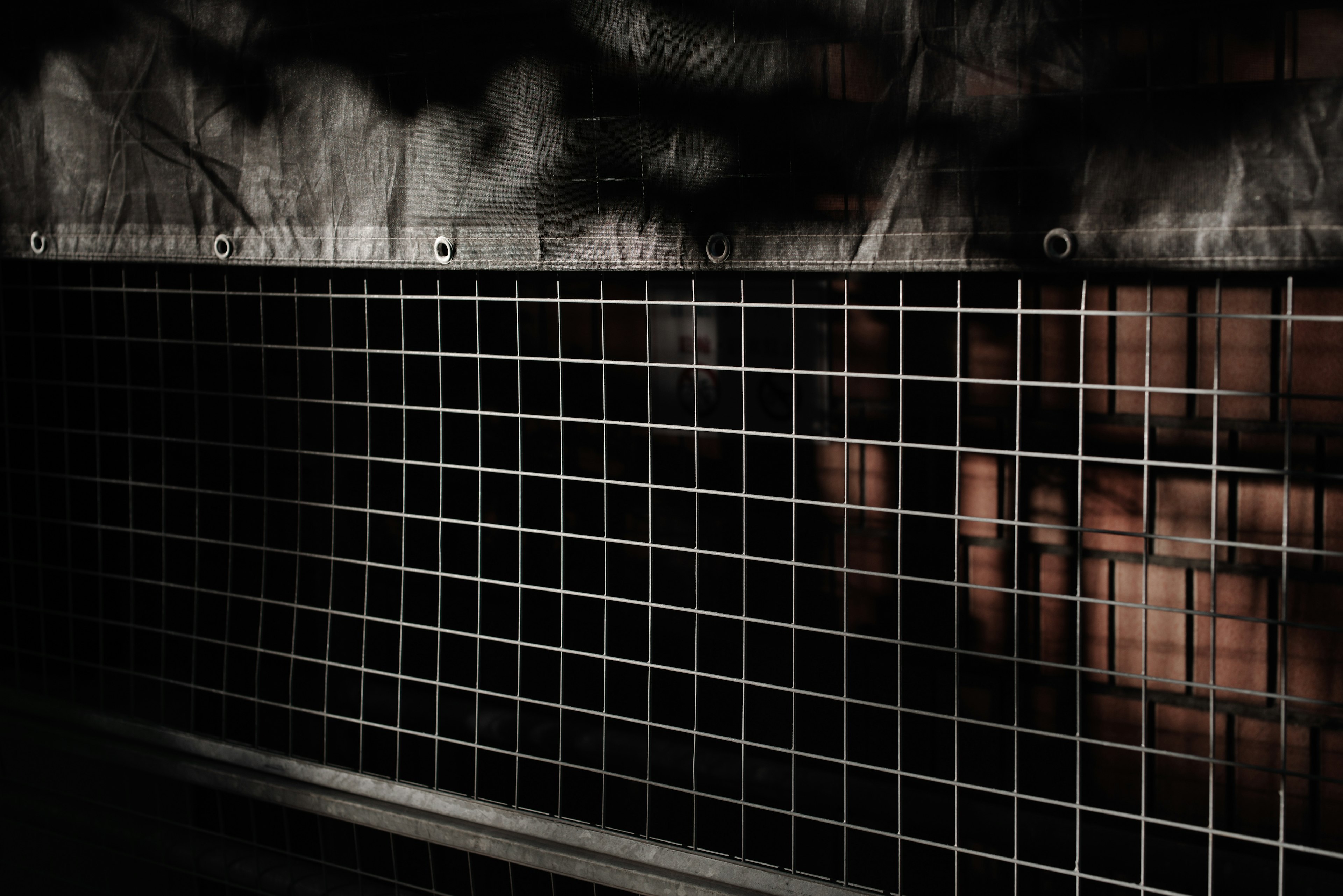 Metal grid pattern against a dark background with shadows