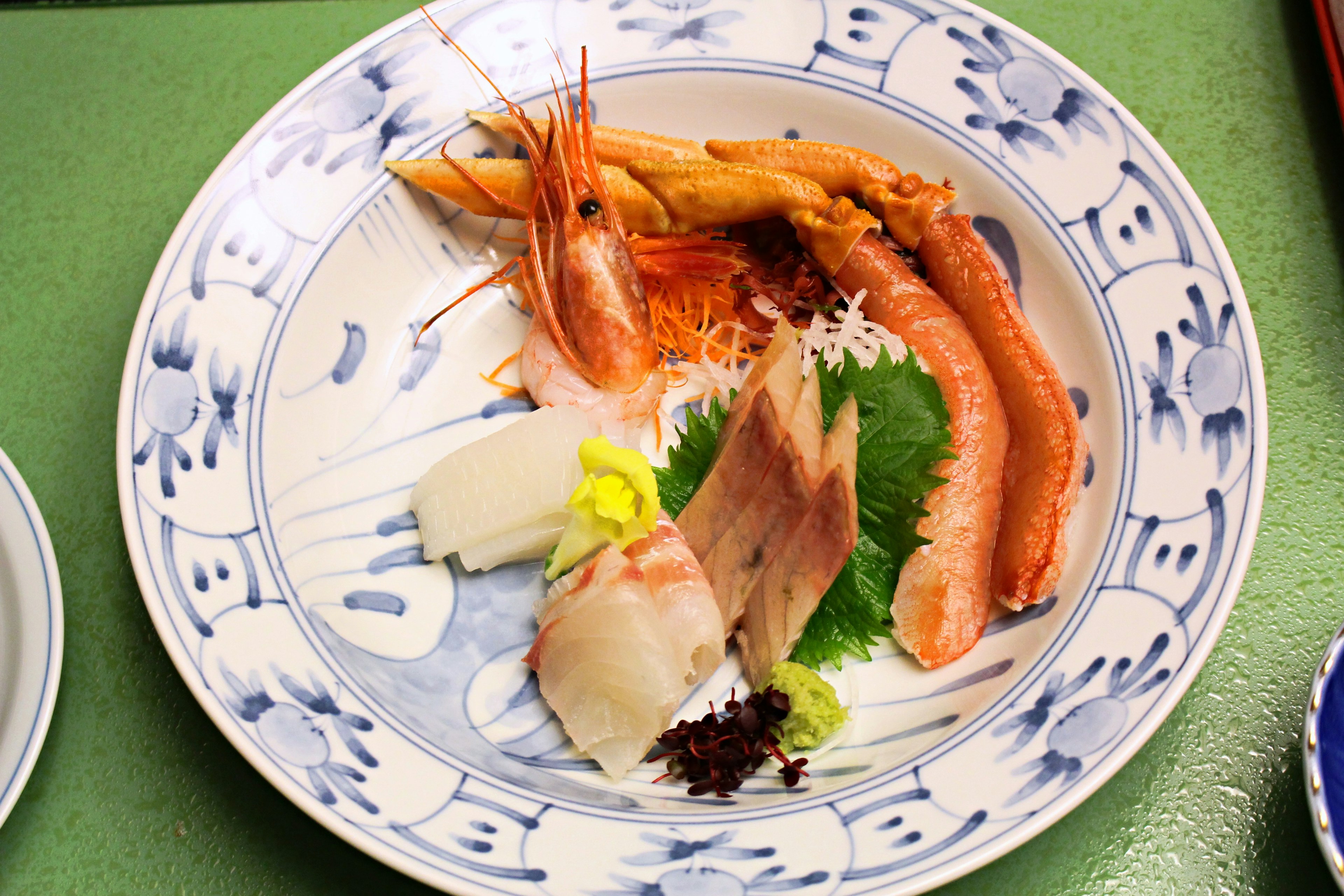 A beautifully arranged plate featuring colorful sashimi and fresh shrimp