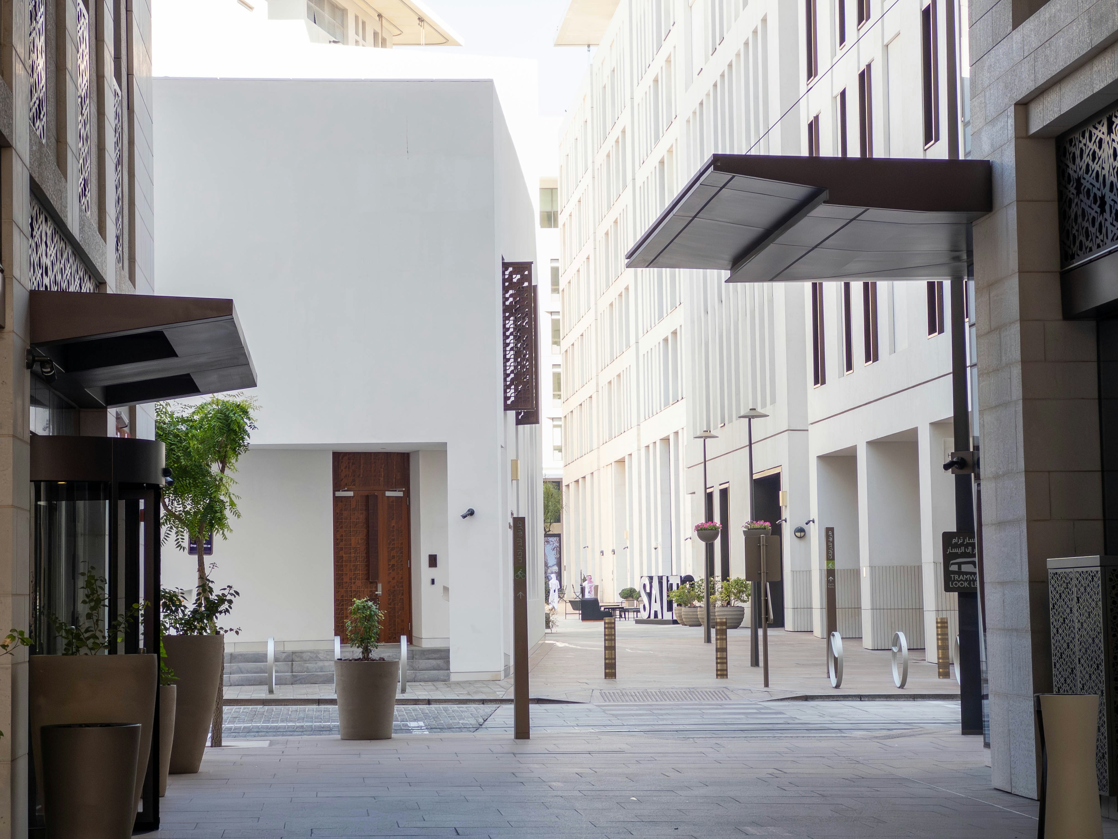 Vue d'une rue moderne avec des bâtiments blancs et des jardinières