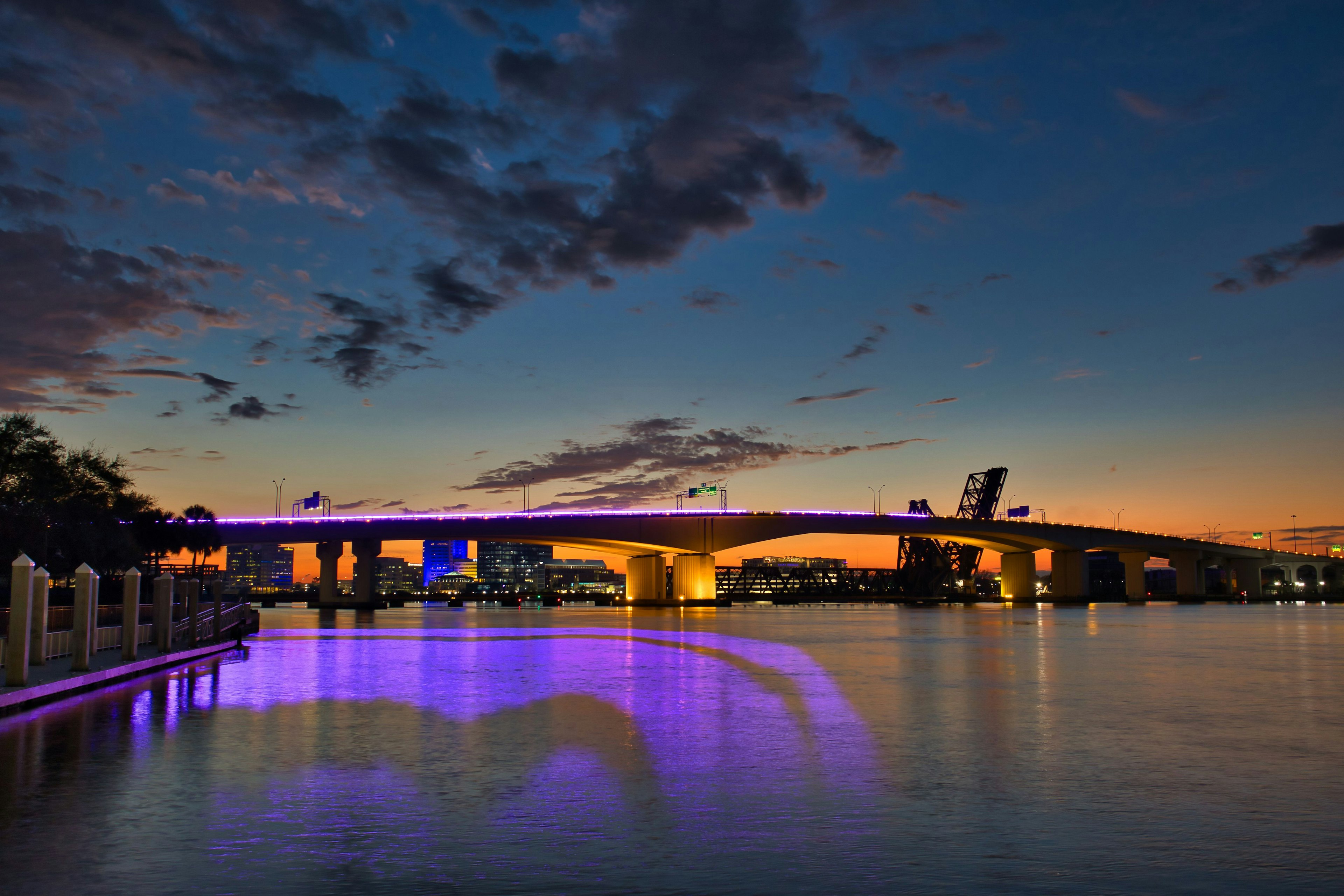 Pont illuminé au crépuscule avec des reflets sur l'eau