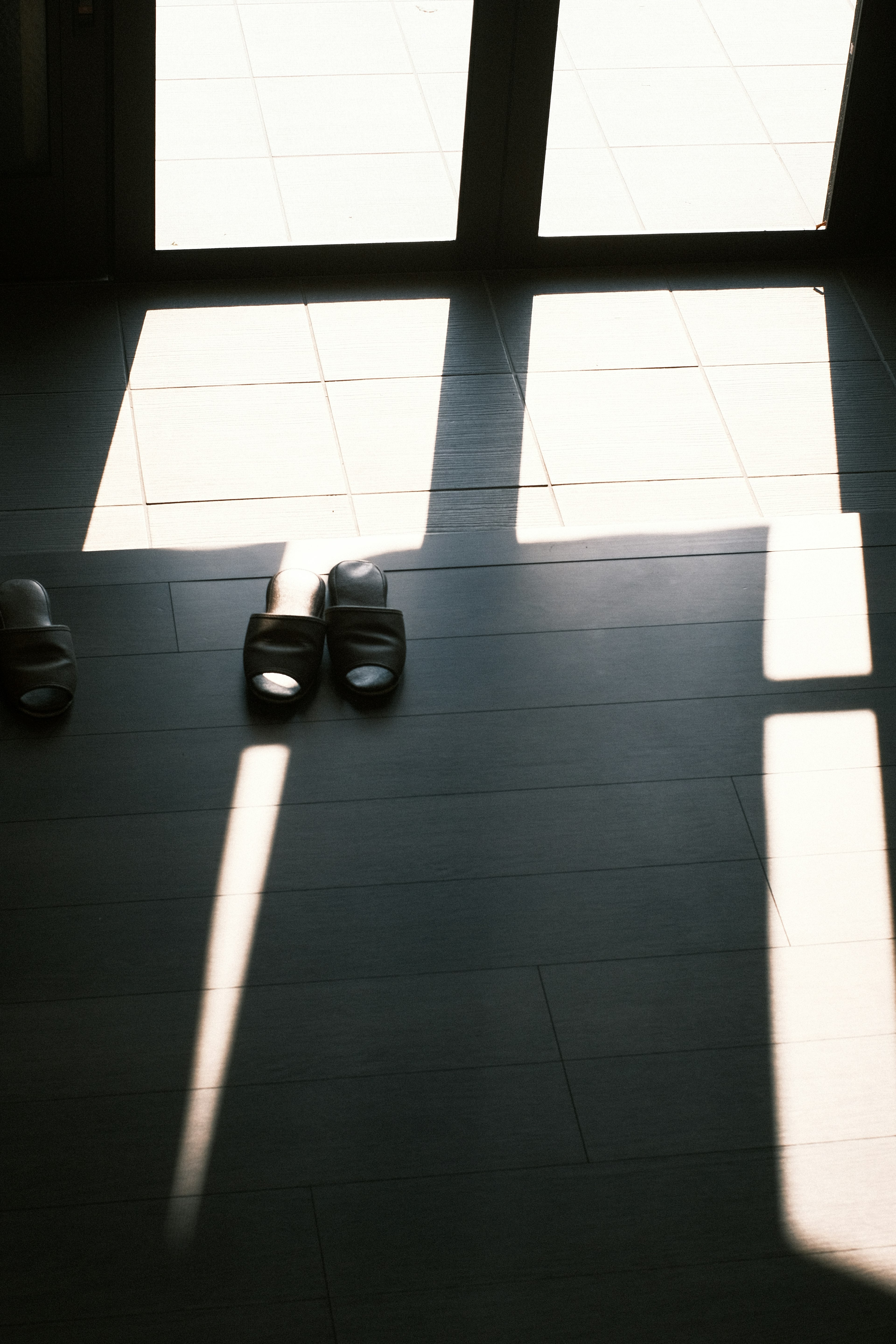 Sombras y patrones de luz en el suelo con sandalias