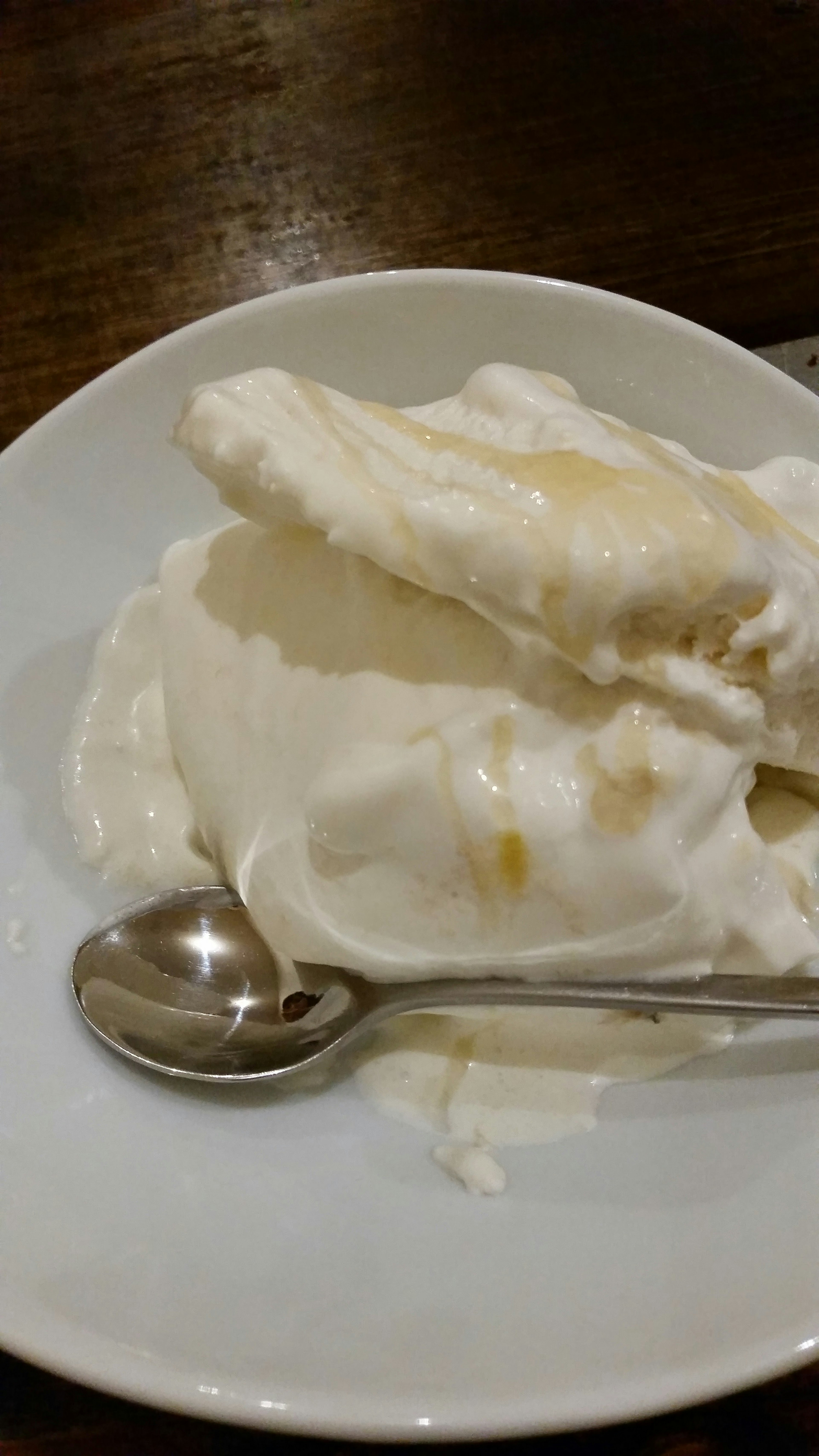 Dessert auf einem Teller mit weißer Creme und einem Löffel serviert