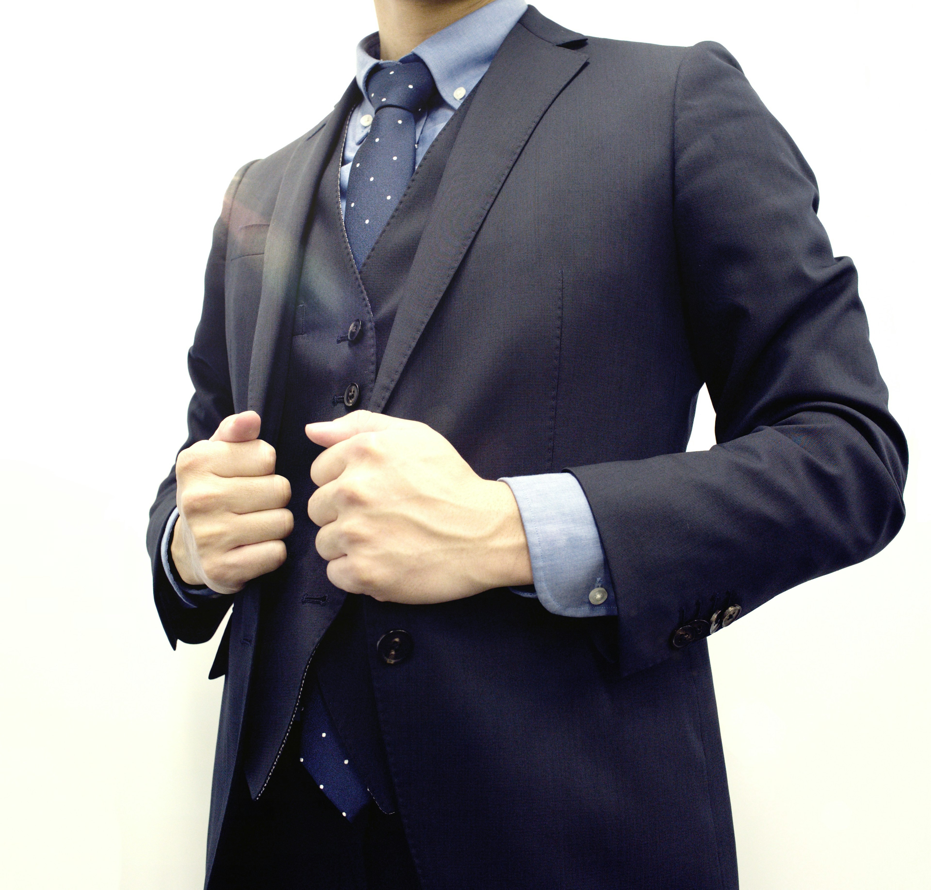 Man posing in a formal suit with a tie