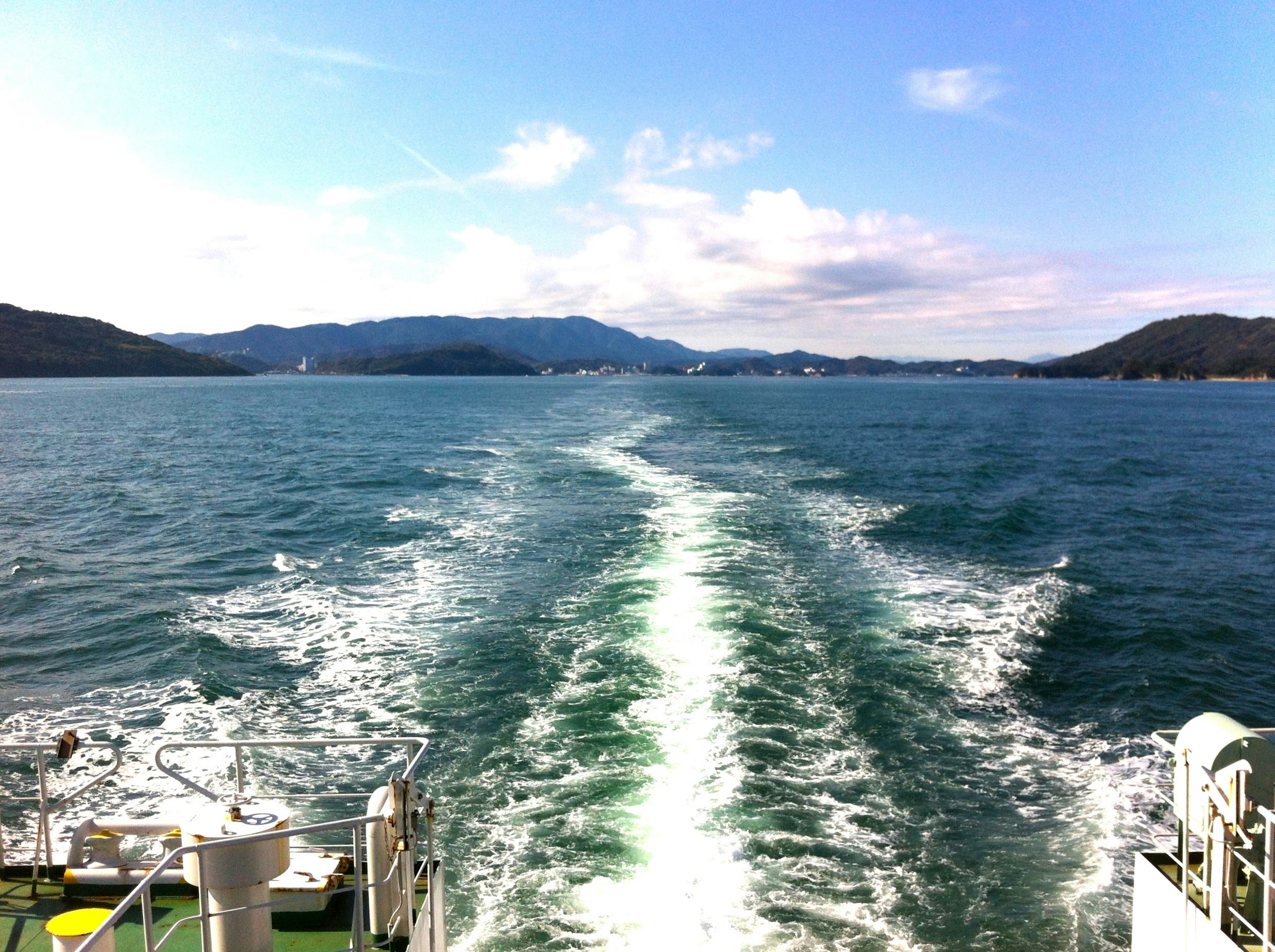 船の後ろに広がる海と島々の風景