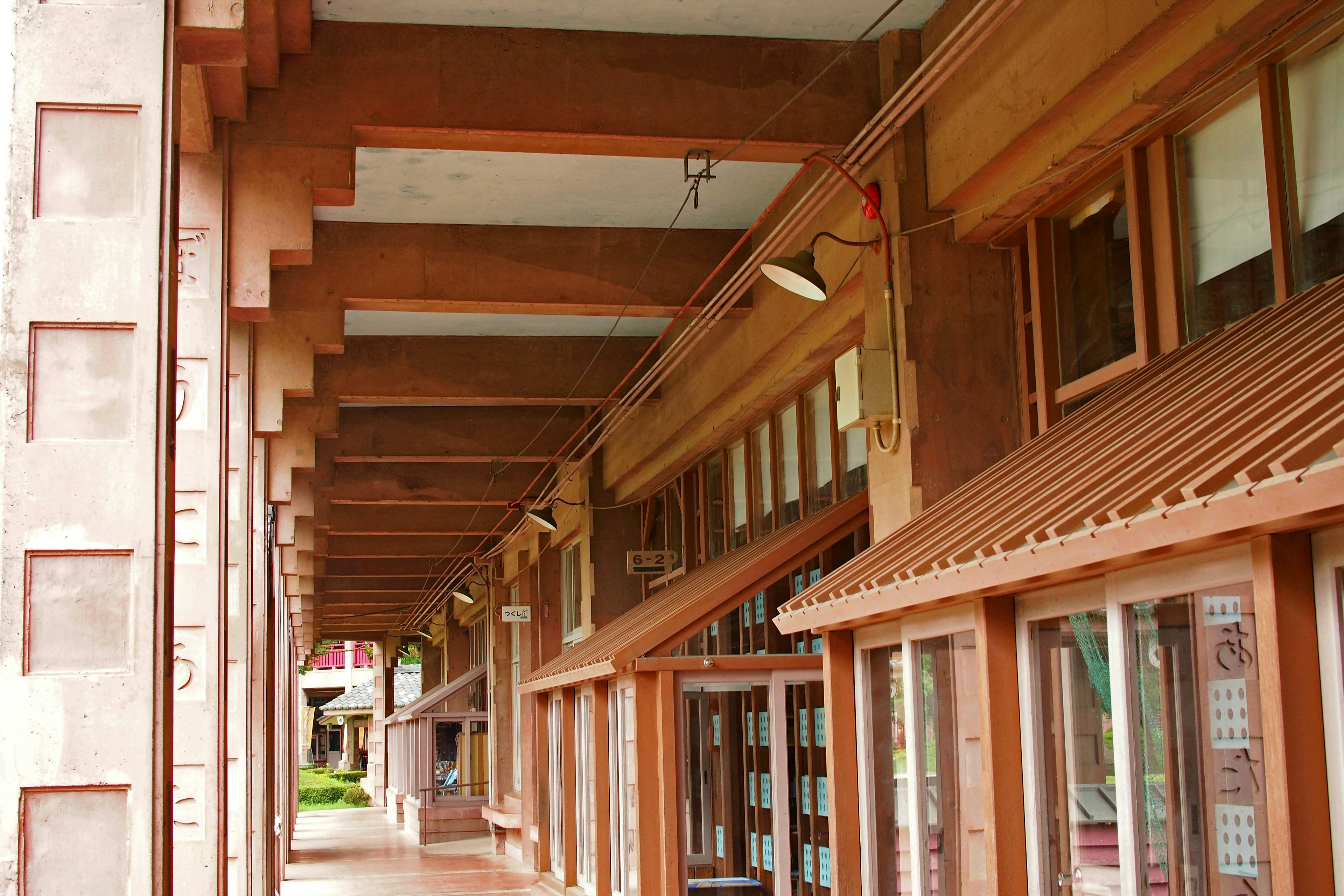 Un couloir sous une belle arcade en bois avec de grandes fenêtres