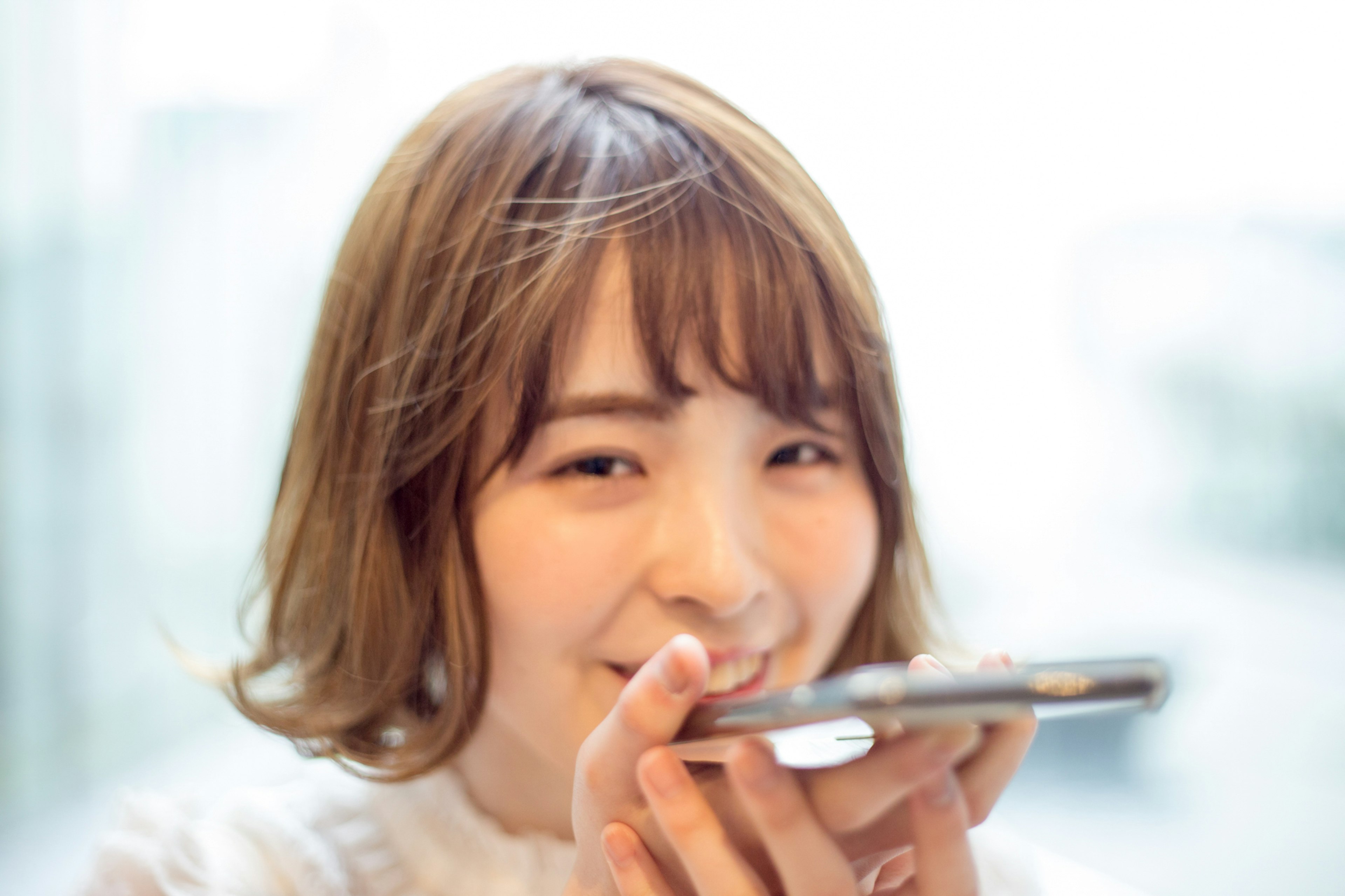 A young woman using a smartphone with a smile