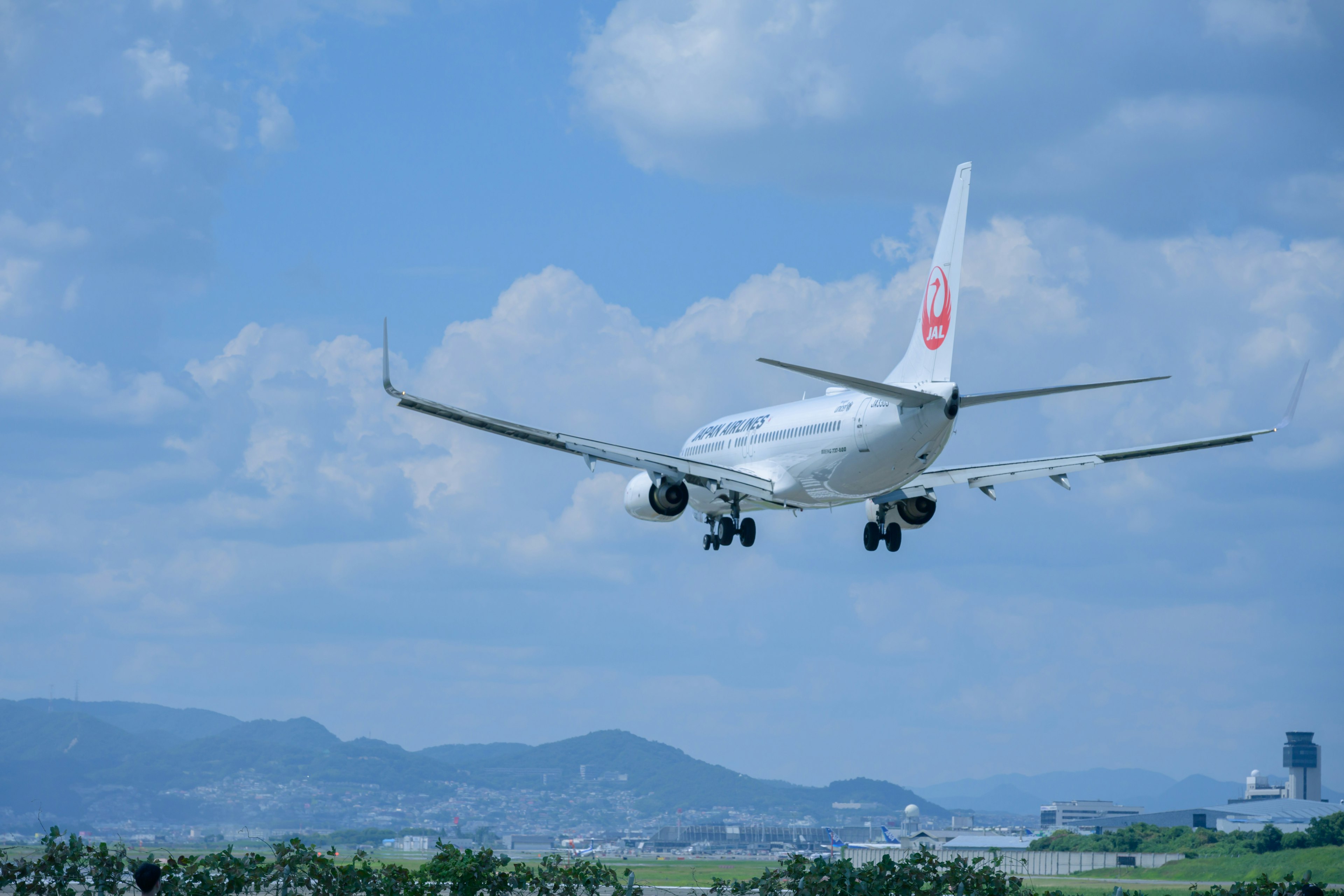 An airplane landing against a blue sky