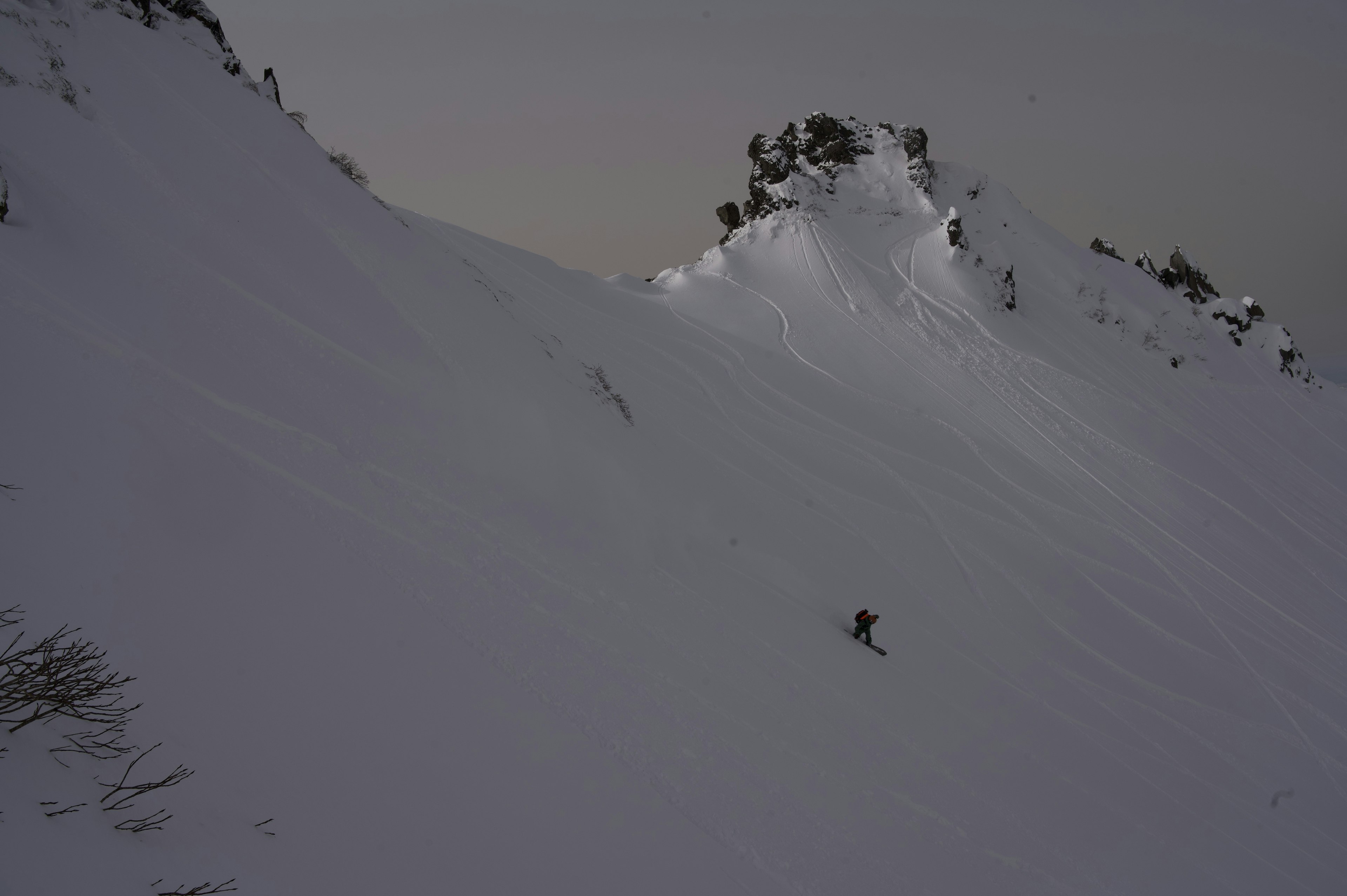 Pendio di montagna coperto di neve con cielo scuro